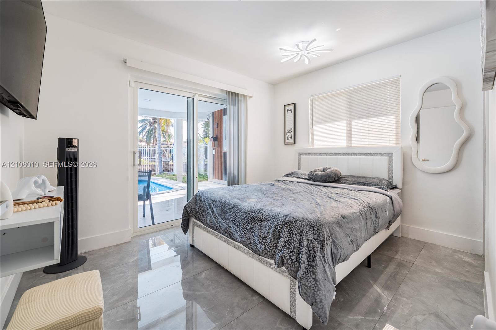 Large-format tile flooring, glass sliding door, and contemporary multi-arm flush mount light fixture