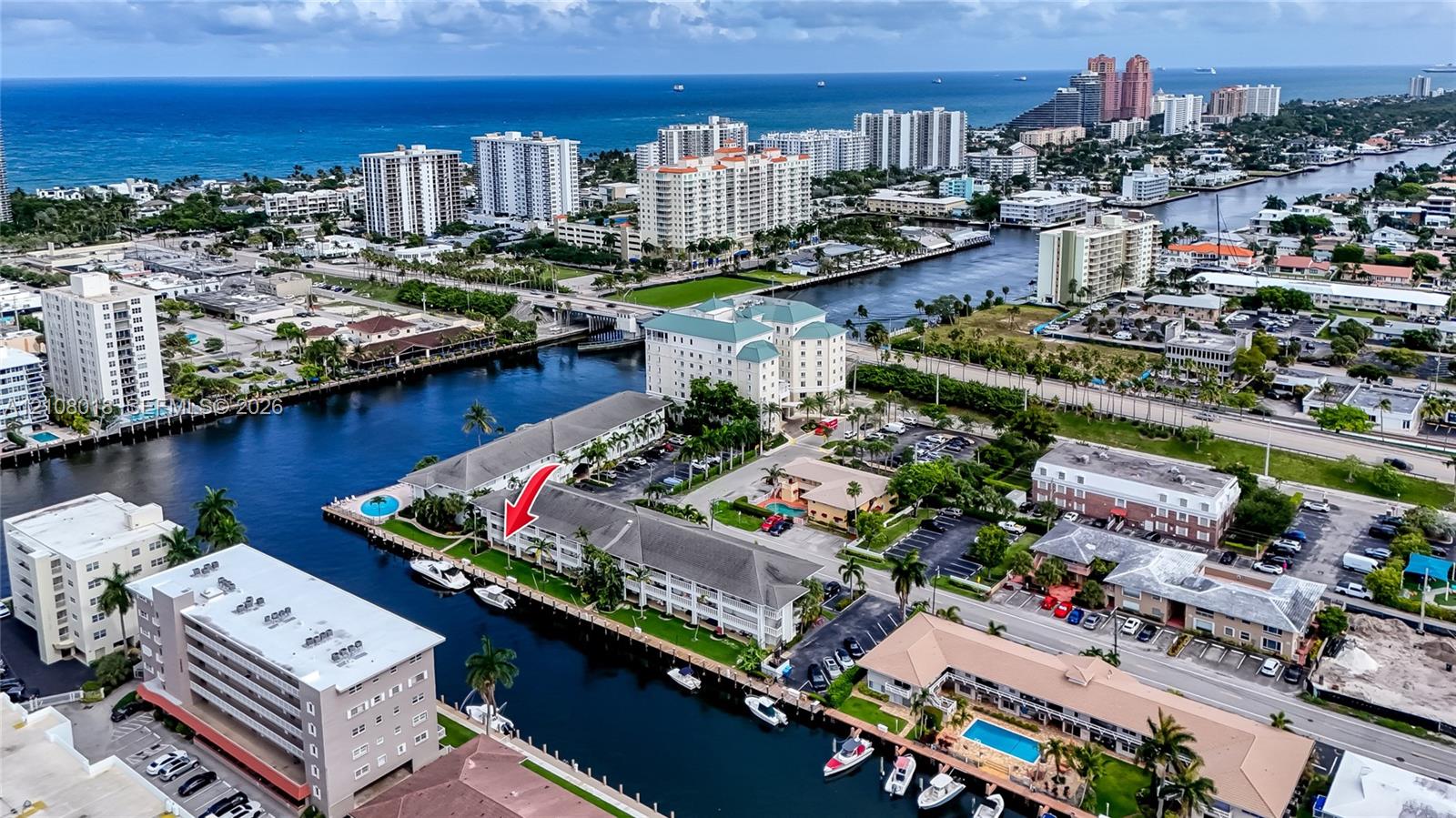 Aerial perspective of multi-story building featuring deep-water canal access, private boat slips, and coastal proximity