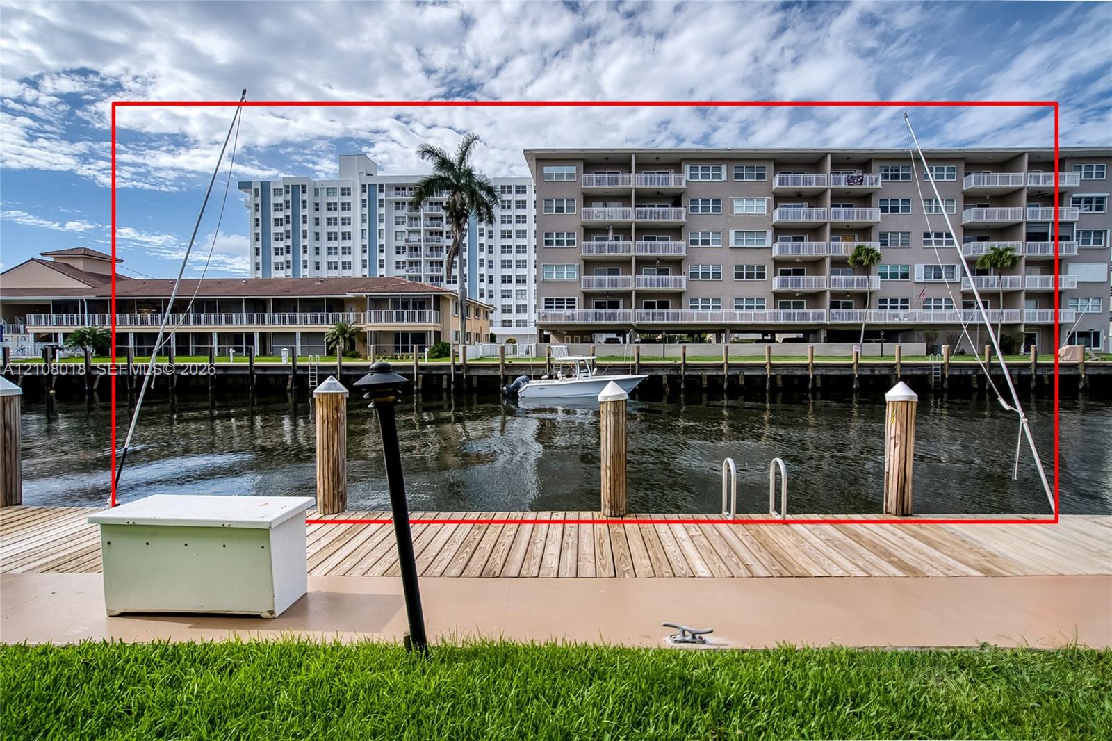 Waterfront bulkhead featuring wood-plank decking, mooring pilings, and a metal boarding ladder