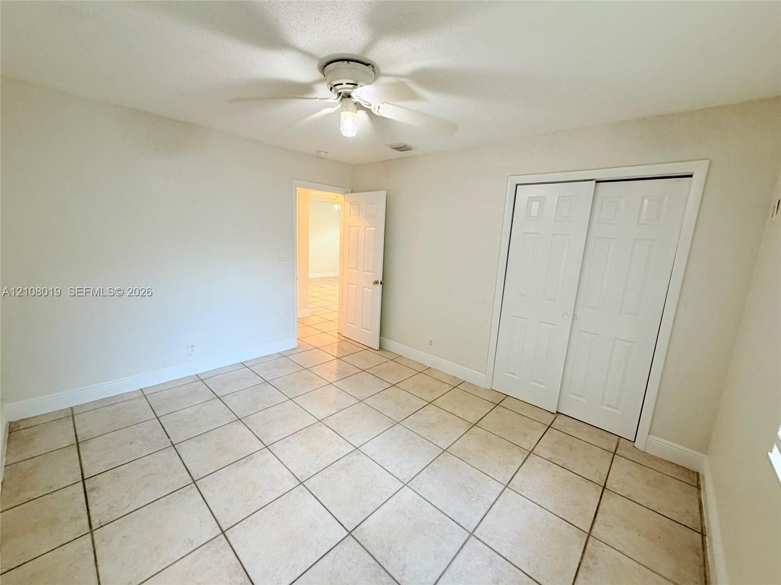 Ceramic tile flooring, ceiling fan with integrated lighting, and dual-panel closet doors