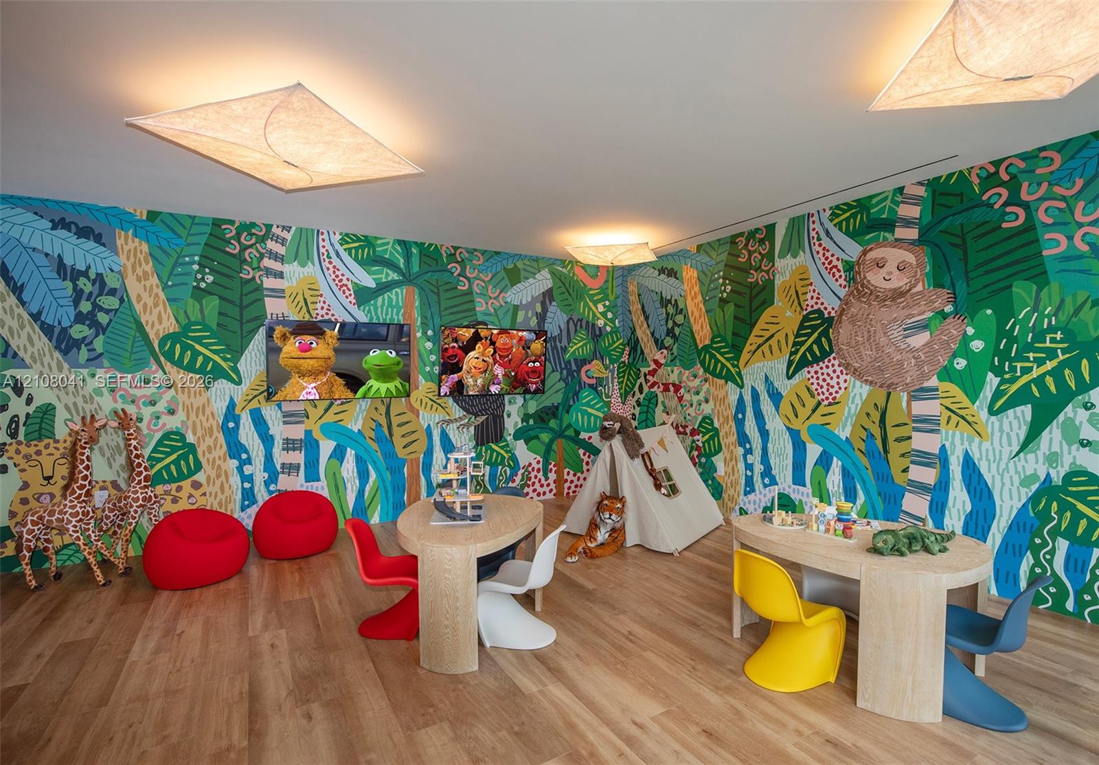 Wood-finish flooring featuring large-format jungle-themed wall murals and geometric flush-mount ceiling lighting