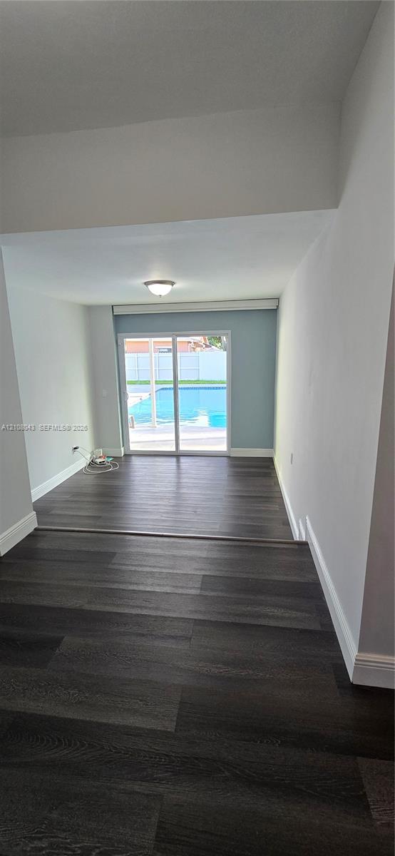 Interior featuring wood-finish flooring, recessed lighting, and sliding glass doors revealing an outdoor swimming pool