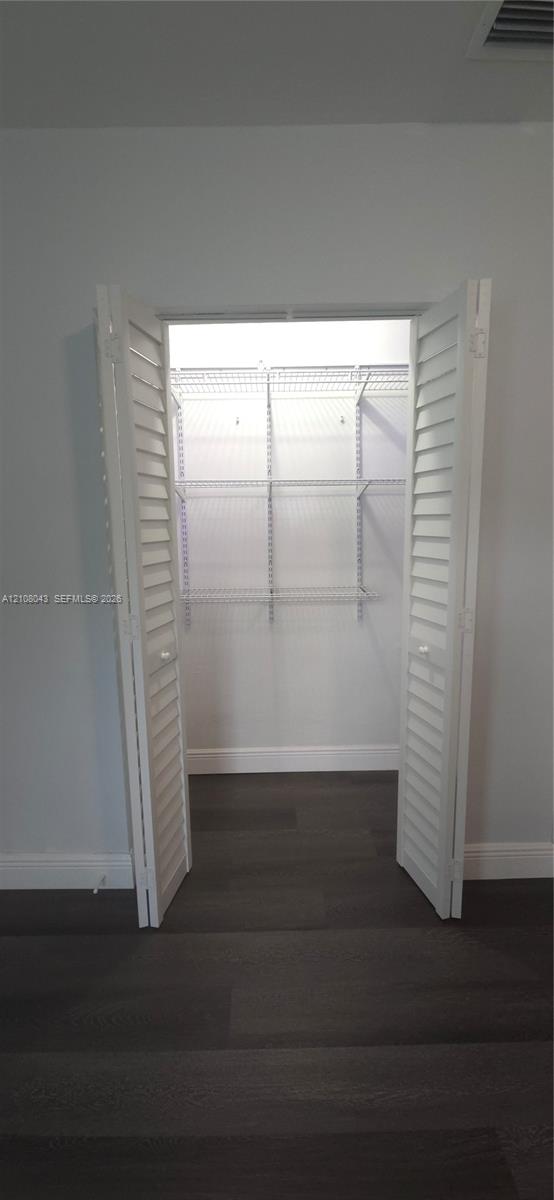 Closet featuring white louvered doors and white wire shelving