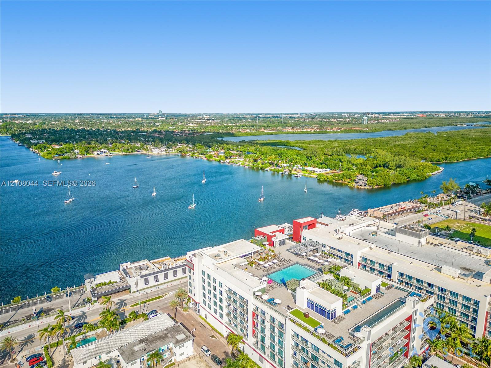 Waterfront property featuring a rooftop pool, multiple terraces, and expansive aquatic scenery