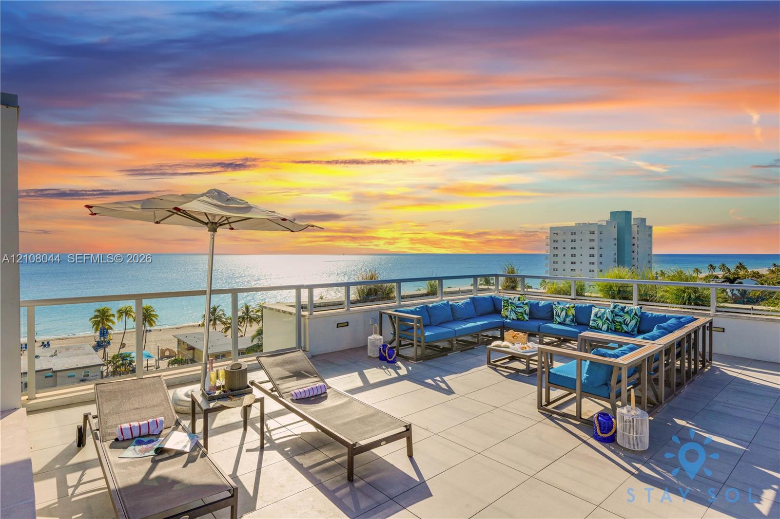 Expansive rooftop terrace featuring large-format stone tile flooring and a glass-paneled safety railing