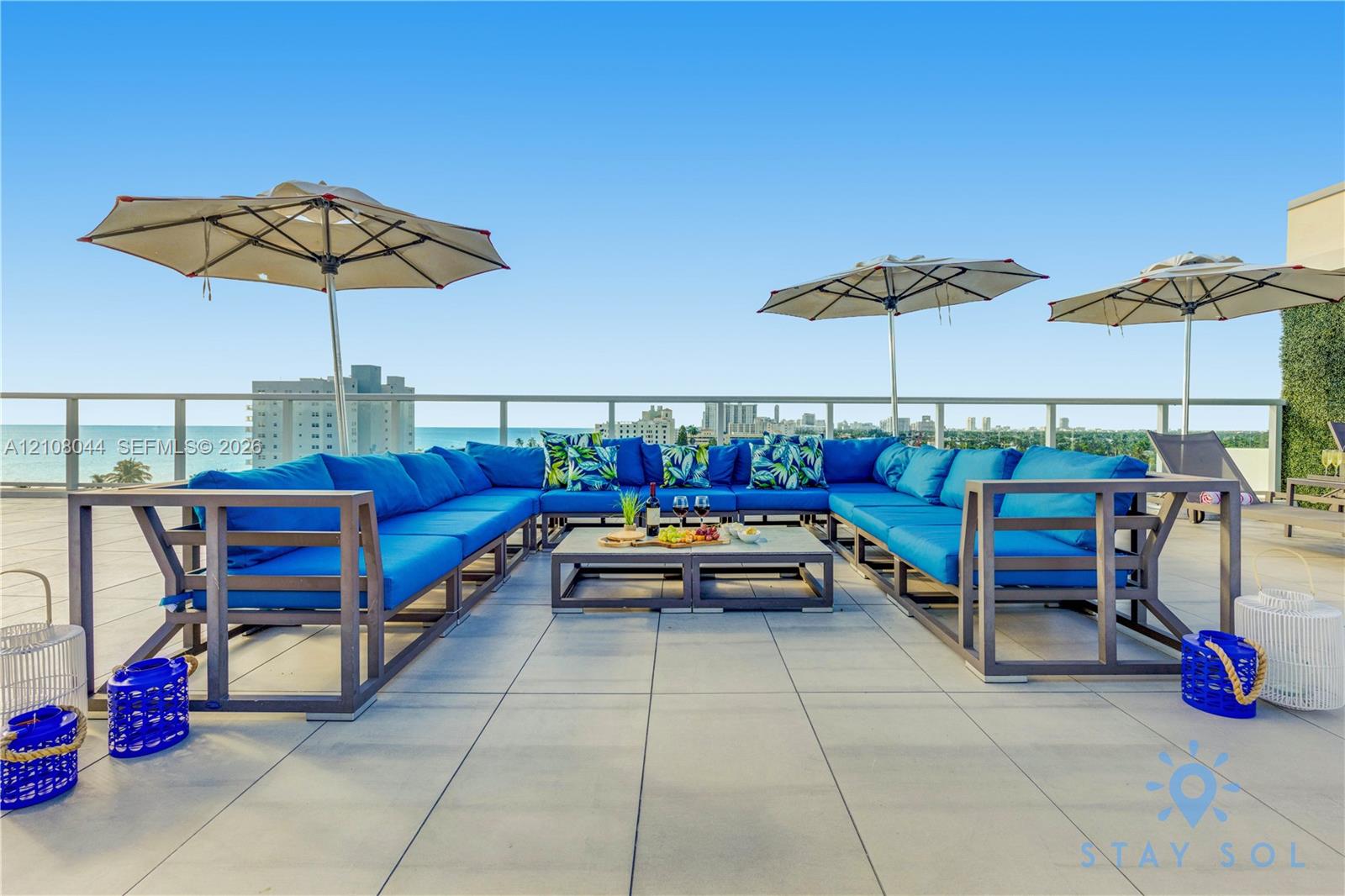 Expansive open-air rooftop terrace featuring large-format tile flooring and a glass panel railing