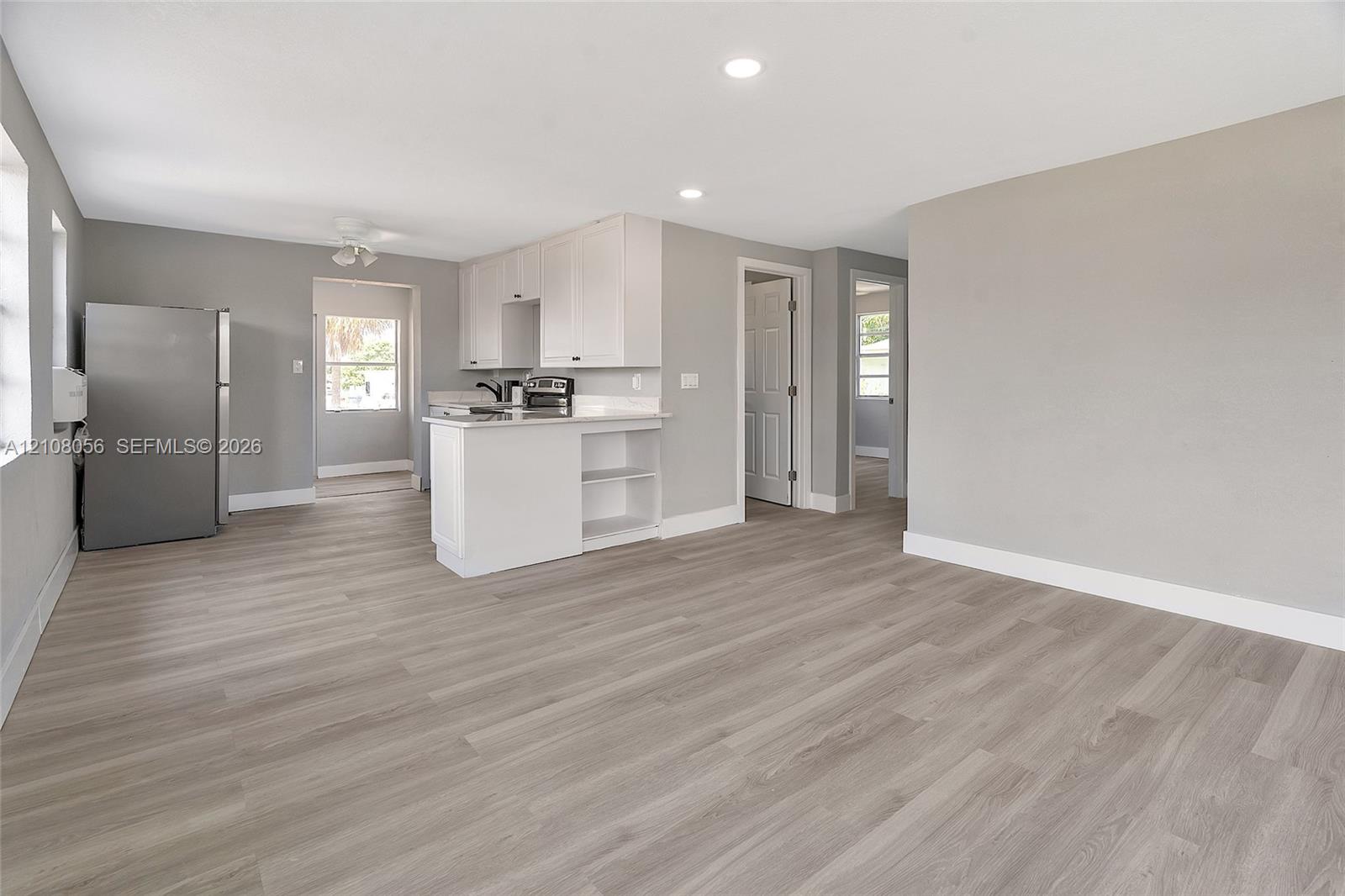 Kitchen featuring white cabinetry, wood-finish flooring, recessed lighting, and a peninsula counter