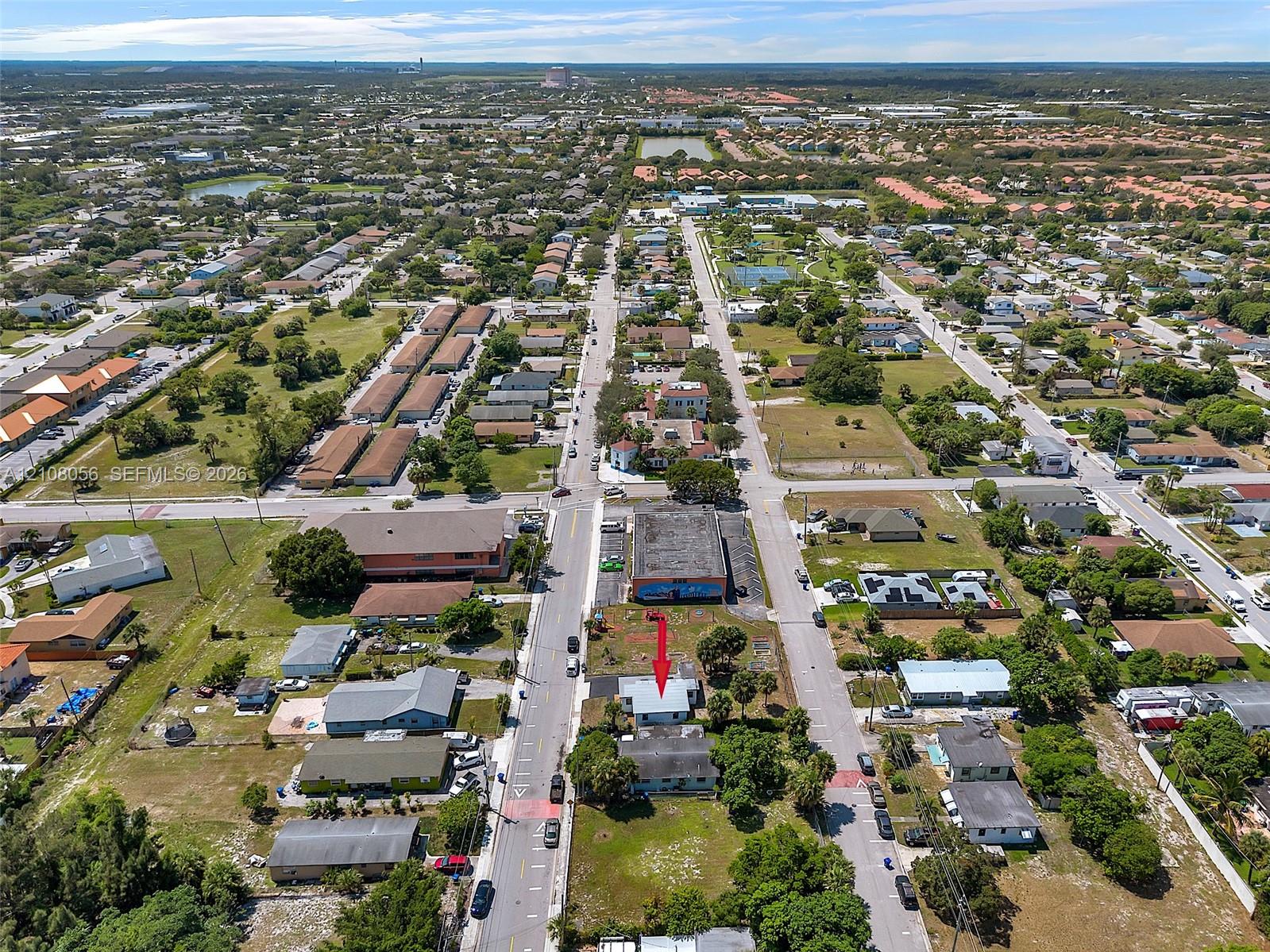 Aerial perspective highlighting a corner lot location with direct street access, proximity to commercial infrastructure, and established landscaping