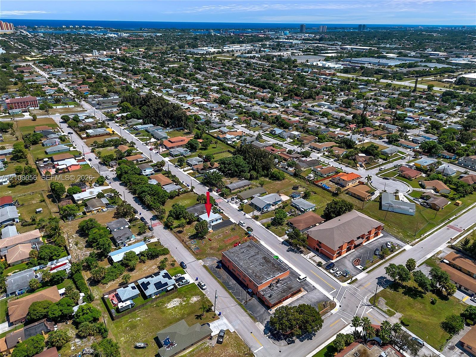 Aerial perspective of a detached property featuring a pitched roof, front-facing exterior entrance, and onsite driveway, situated within a coastal region