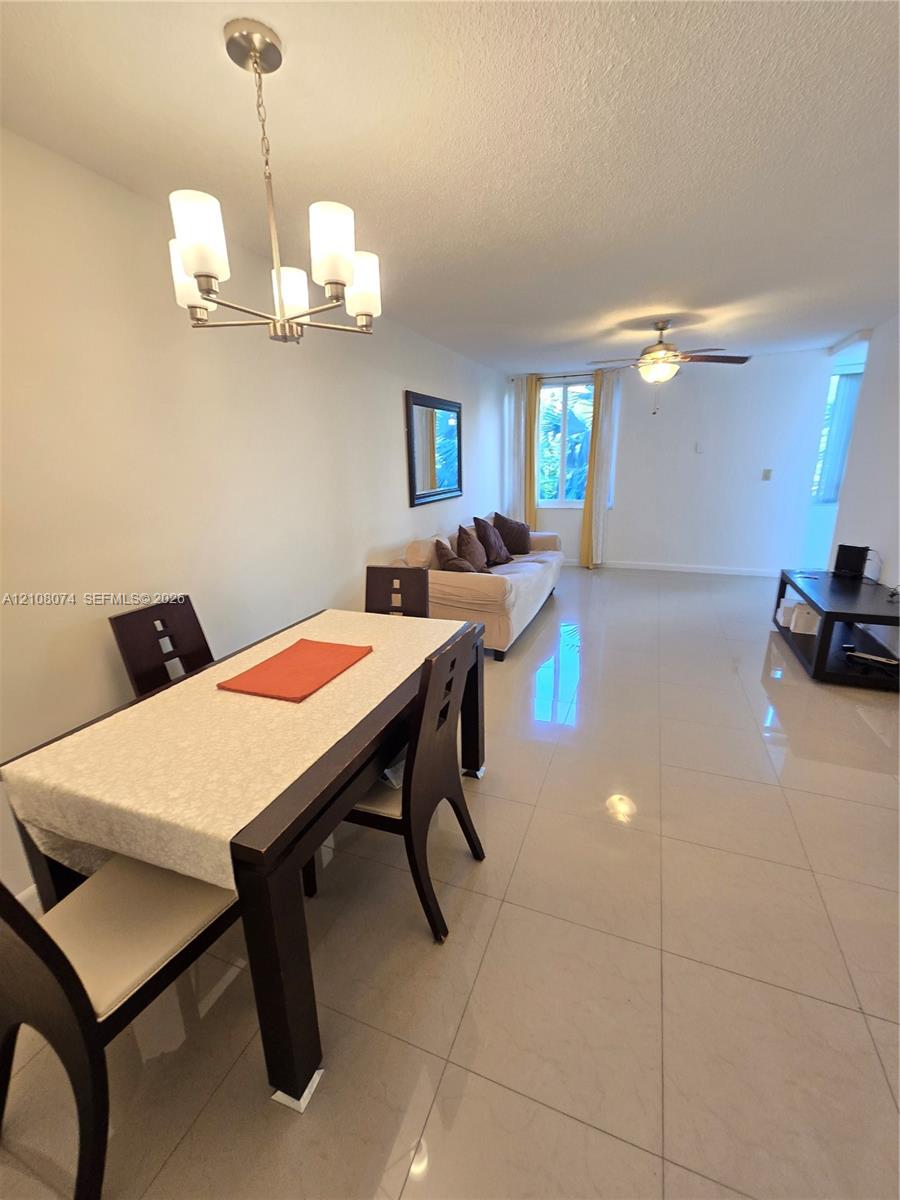 Large-format tile flooring, multi-light chandelier, and ceiling fan with integrated lighting Large-format tile flooring, multi-light chandelier, and ceiling fan with integrated lighting