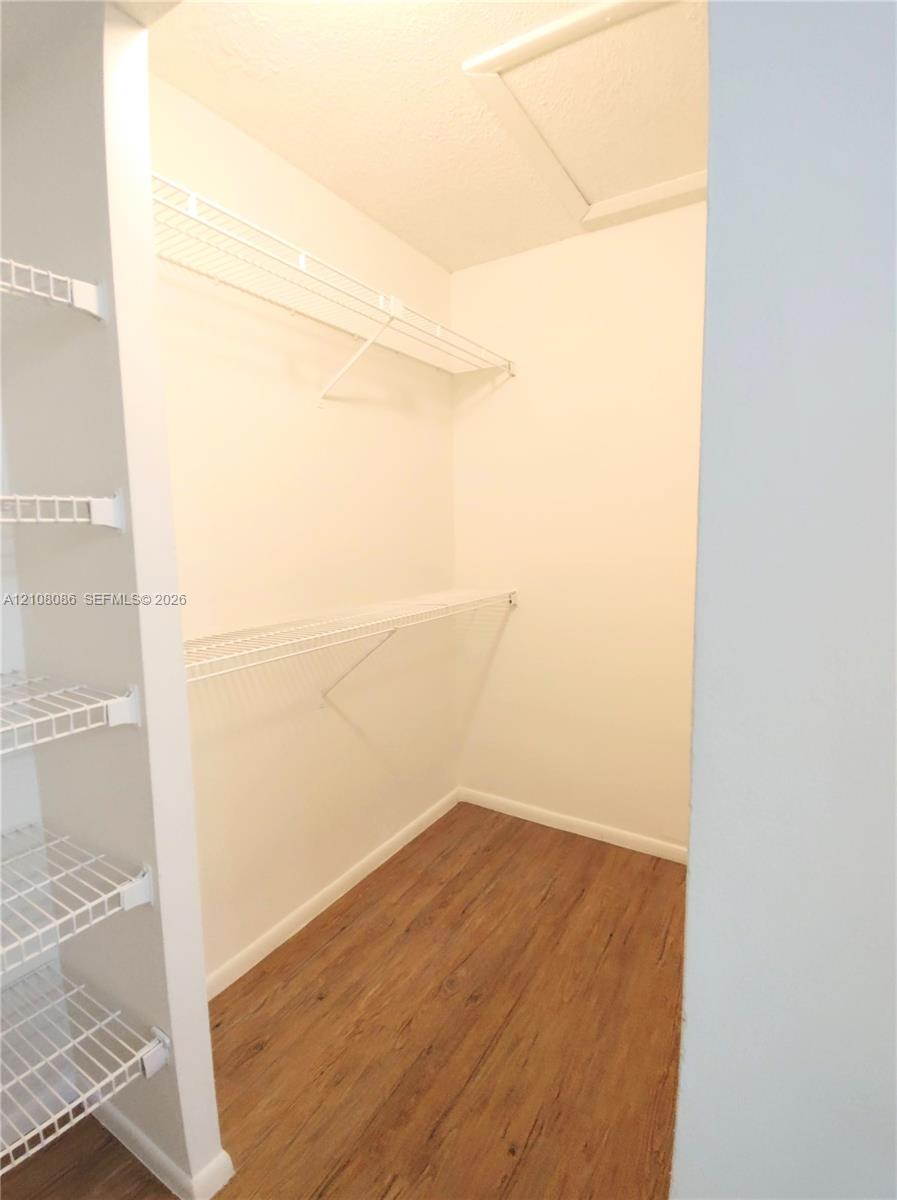 Storage space featuring wood-finish flooring and white wire shelving units
