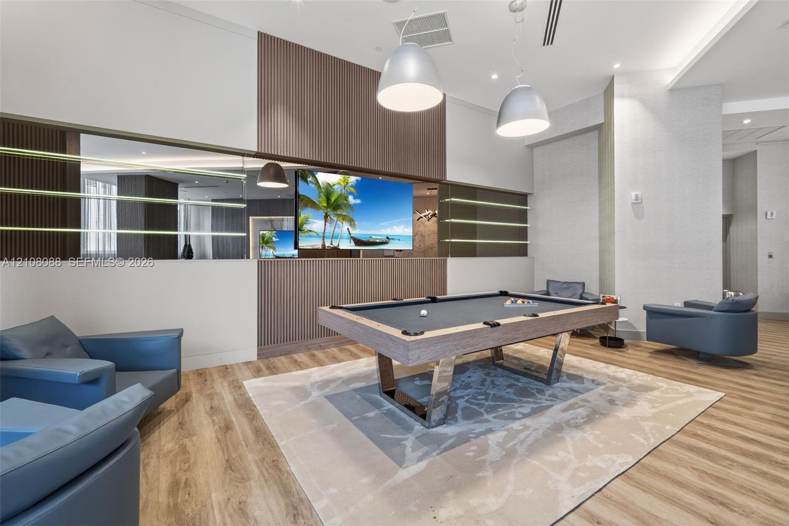 Custom feature wall with vertical wood-slat paneling, integrated glass shelving, expansive horizontal mirror, wood-finish flooring, and dual metallic dome pendant lighting