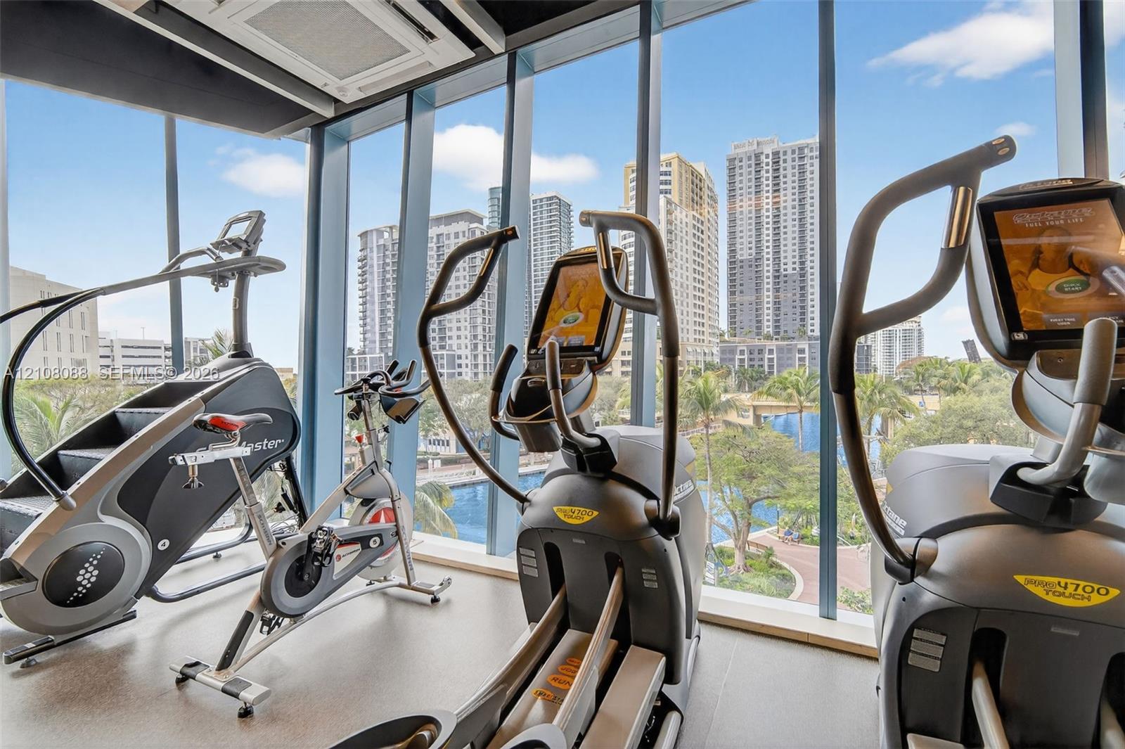 Floor-to-ceiling windows featuring urban scenery and neutral-tone flooring