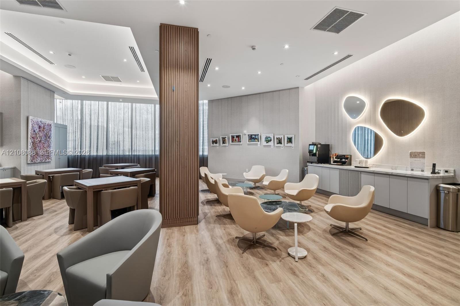 Wood-finish flooring, vertical slat wood-clad structural pillar, recessed ceiling lighting, and built-in cabinetry with integrated countertop