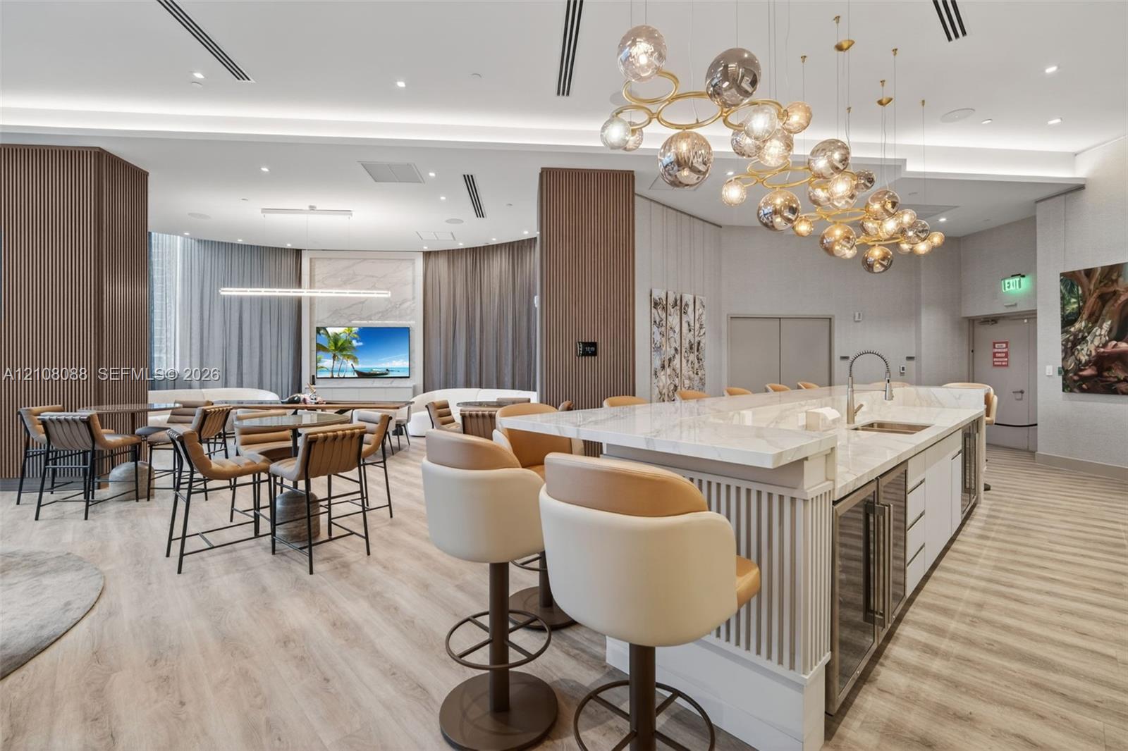 Kitchen featuring a stone-surface island, integrated beverage refrigerator, wood-finish flooring, recessed lighting, and a multi-globe pendant light fixture