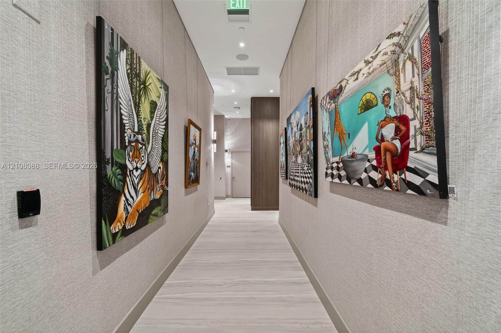 Hallway featuring textured wall coverings, recessed ceiling lighting, wood-finish flooring, and wood-panel accents