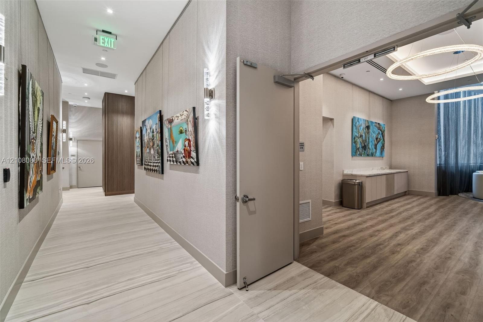 Hallway featuring neutral textured wall coverings, polished stone-finish flooring, wood-finish flooring, recessed lighting, and integrated wall-mounted sconces
