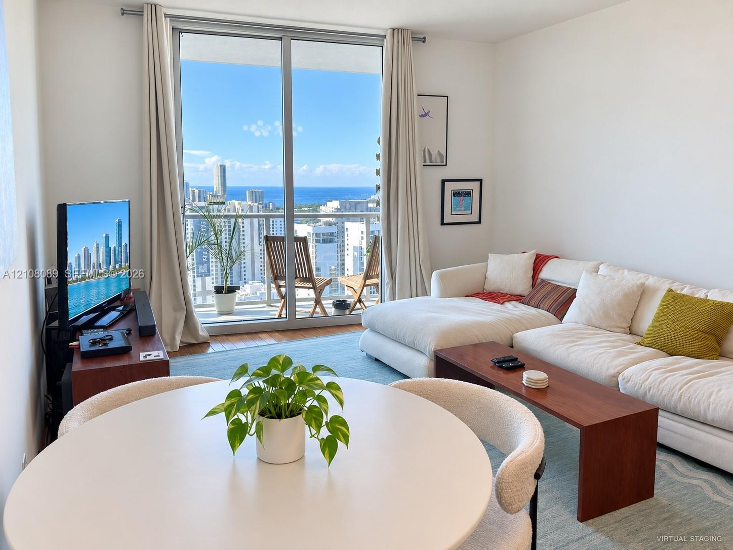 Full-height sliding glass doors with access to a private balcony, wood-finish flooring, and expansive natural light
