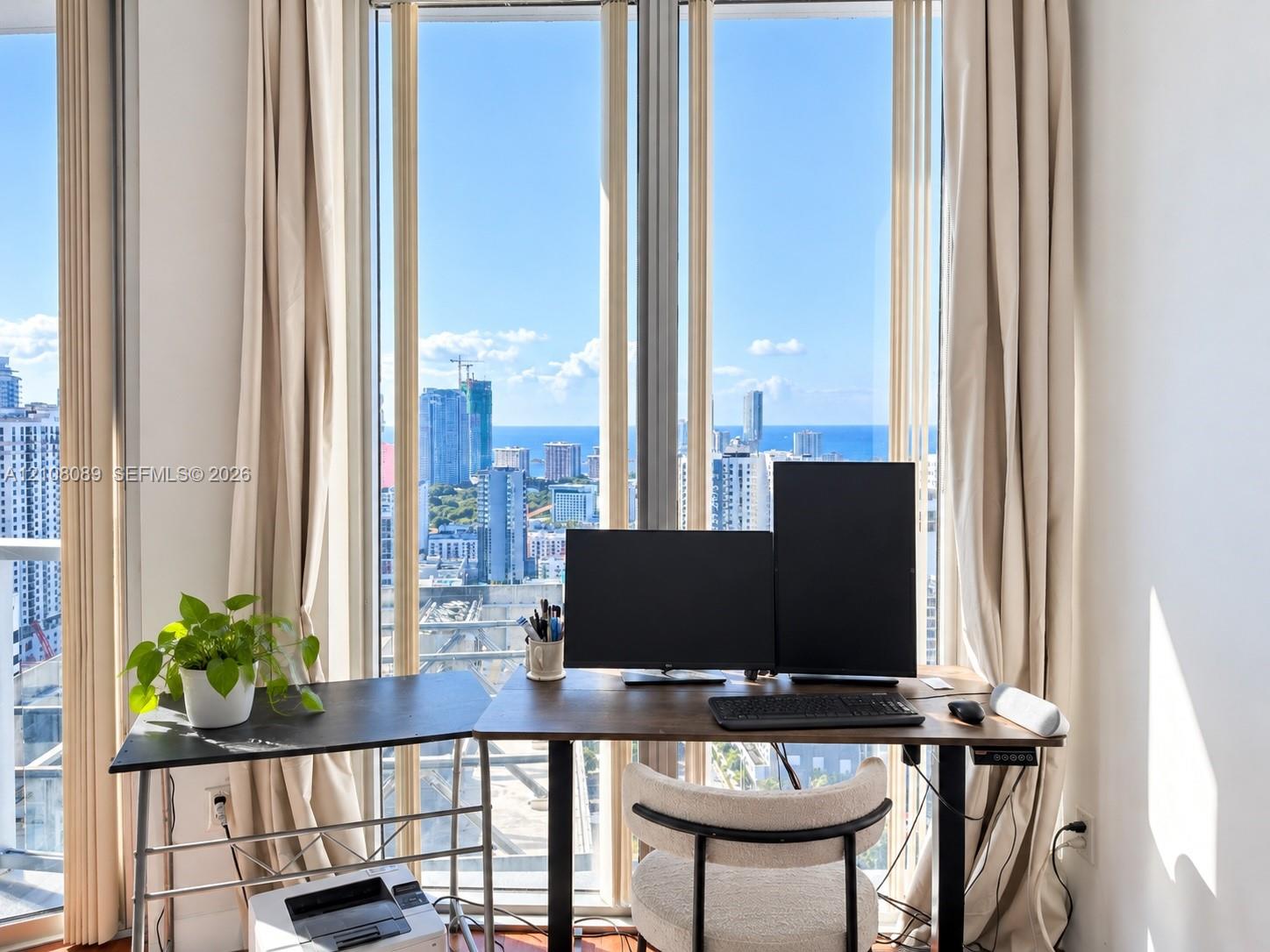 Floor-to-ceiling windows featuring urban and ocean scenery