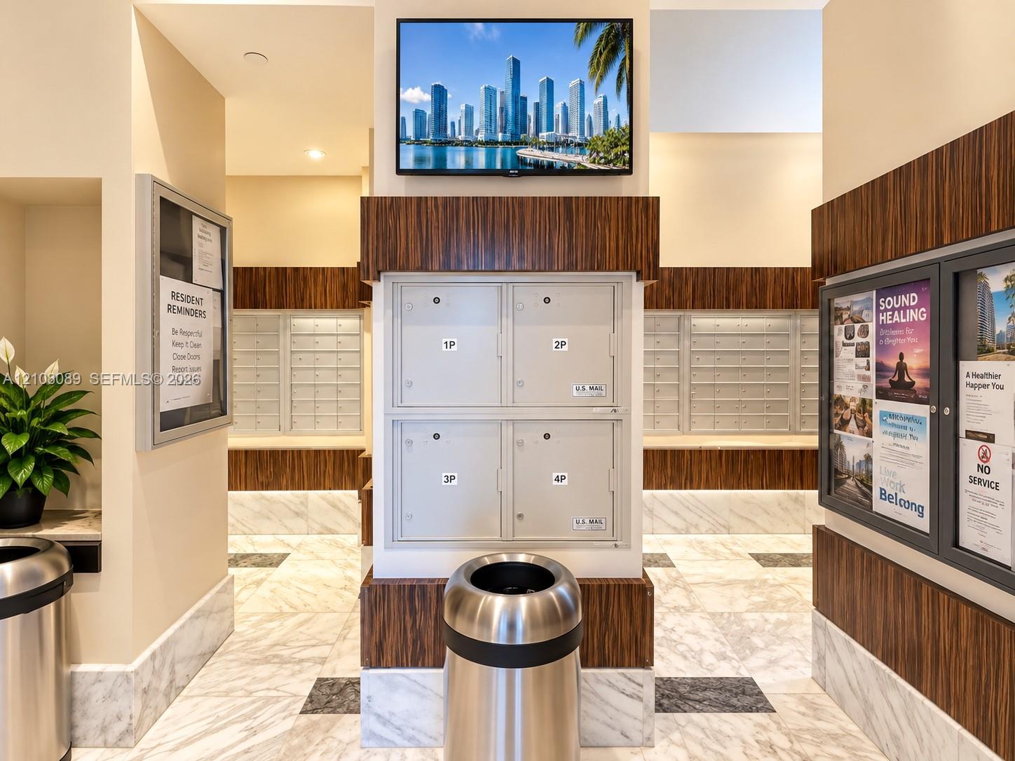 Mail center area featuring integrated parcel lockers, wood-finish wall paneling, and stone tile flooring
