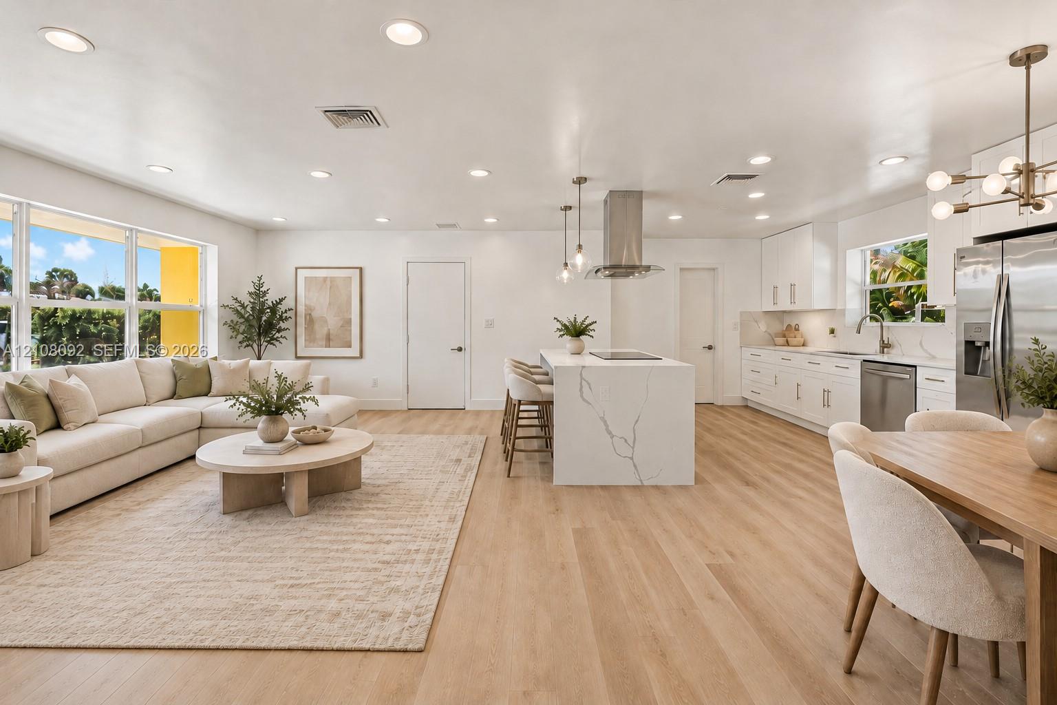 Kitchen featuring a central island with a stone-finish countertop and built-in electric cooktop, stainless steel chimney-style range hood, recessed ceiling lighting, and wood-finish flooring