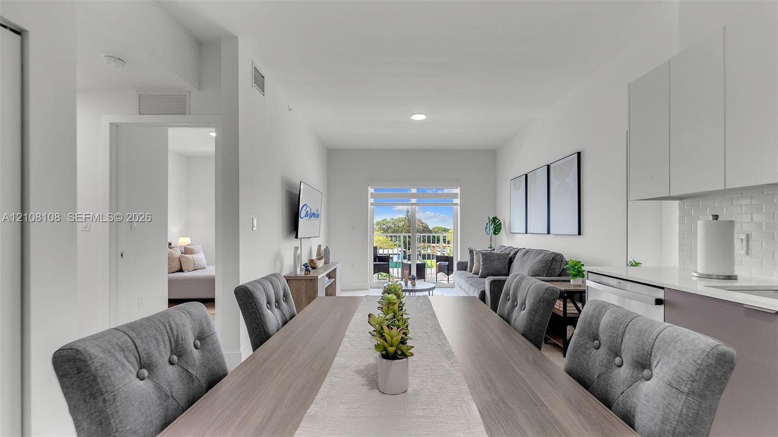 Open-concept living space featuring high ceilings, recessed lighting, and sliding glass doors providing outdoor access Open-concept living space featuring high ceilings, recessed lighting, and sliding glass doors providing outdoor access