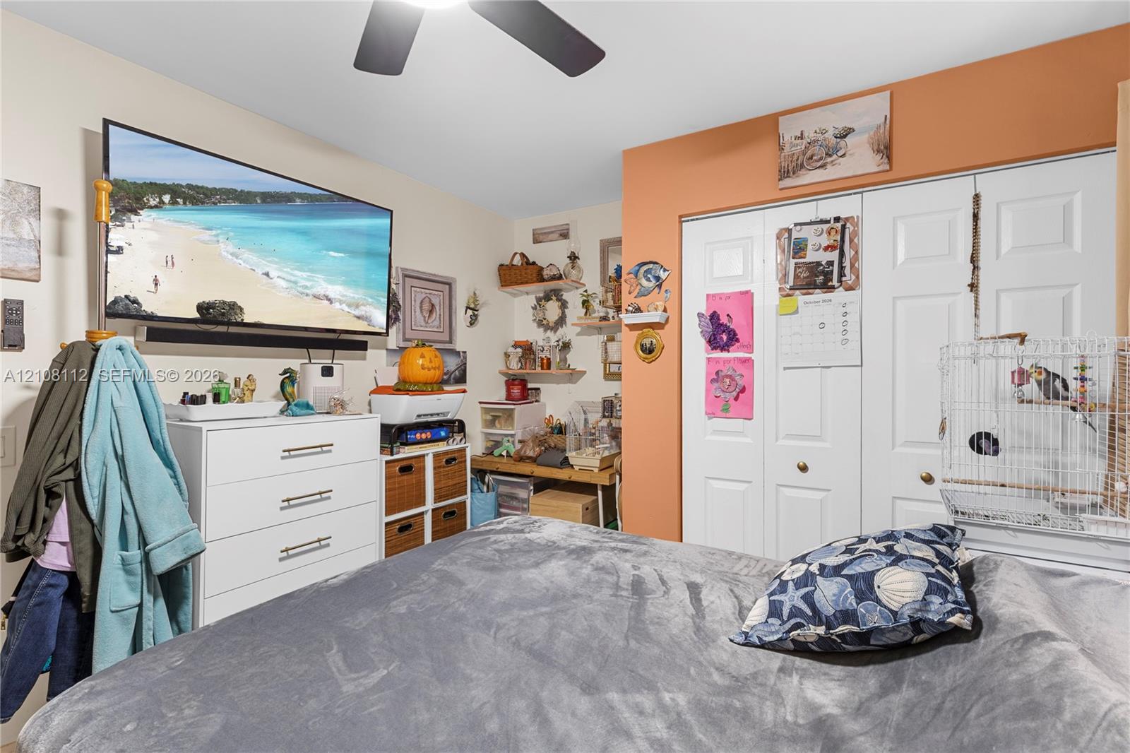 Room featuring double-panel closet doors, wall-mounted shelving, and a ceiling fan