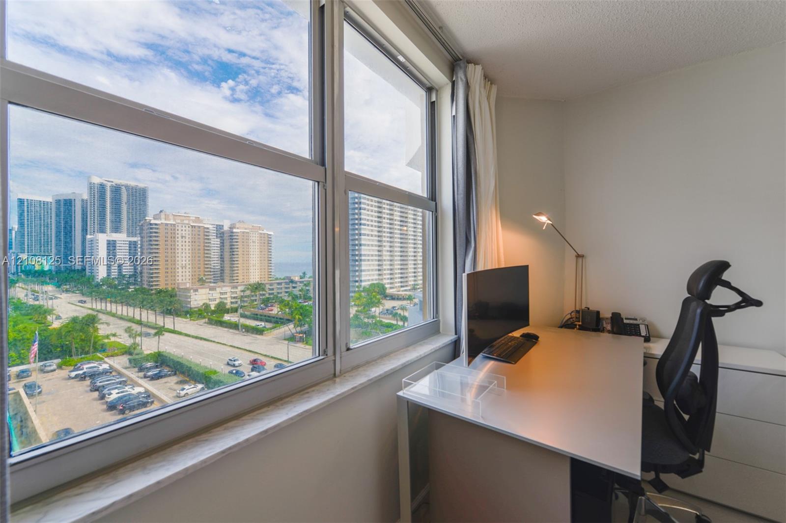 Floor-to-ceiling windows featuring urban scenery and a stone window sill