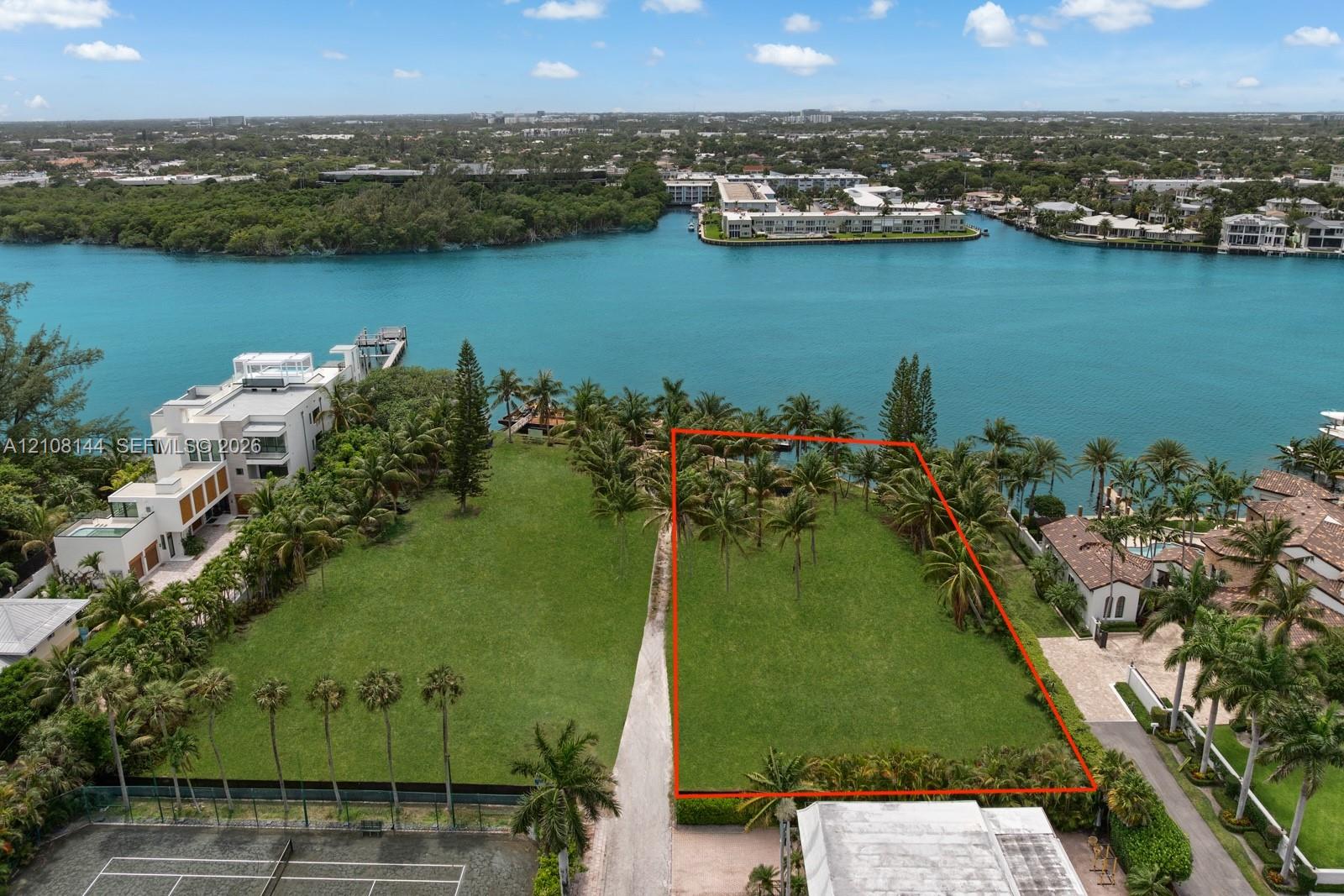 Waterfront parcel featuring direct water access, mature palm trees, and an expansive grass lawn