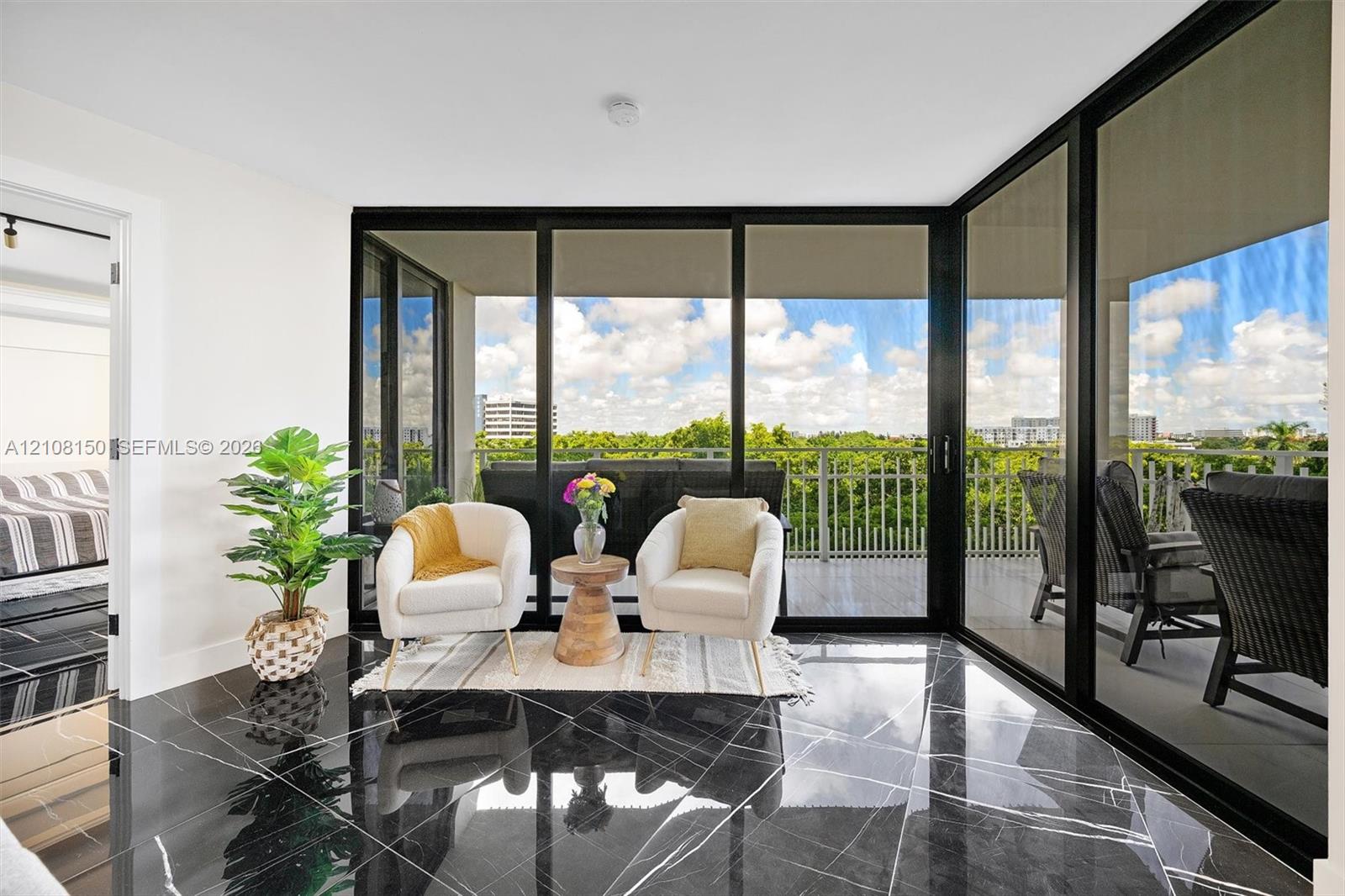 Polished dark stone tile flooring, expansive floor-to-ceiling glass walls, and a private outdoor balcony with metal railing Polished dark stone tile flooring, expansive floor-to-ceiling glass walls, and a private outdoor balcony with metal railing