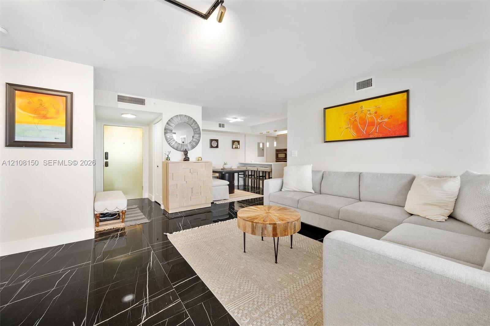 Polished black stone-finish flooring with white veining, recessed lighting, and kitchen island with pendant fixtures Polished black stone-finish flooring with white veining, recessed lighting, and kitchen island with pendant fixtures