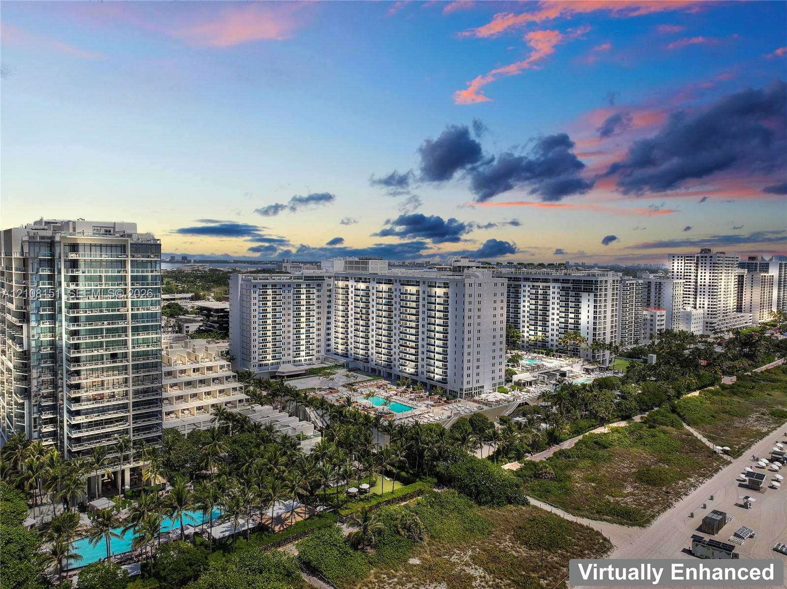 High-rise residential complex featuring swimming pools, sun decks, landscaped grounds, and immediate proximity to the coastline