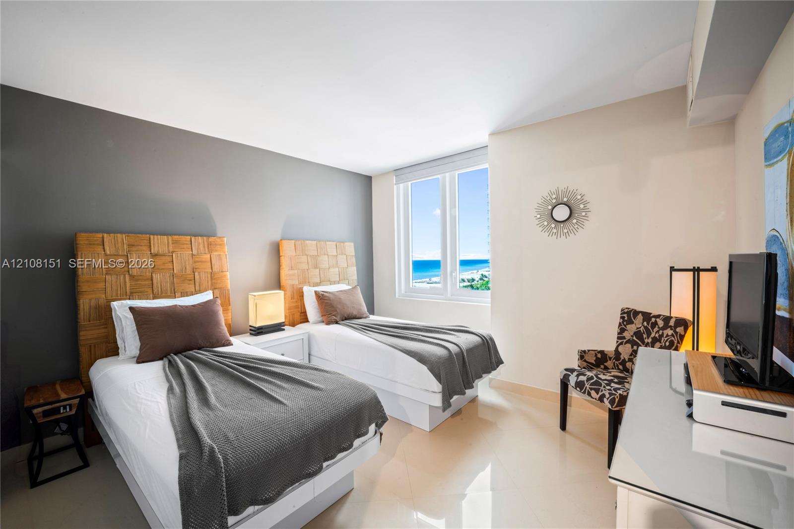 Bedroom featuring large dual-pane windows with ocean scenery and polished tile flooring