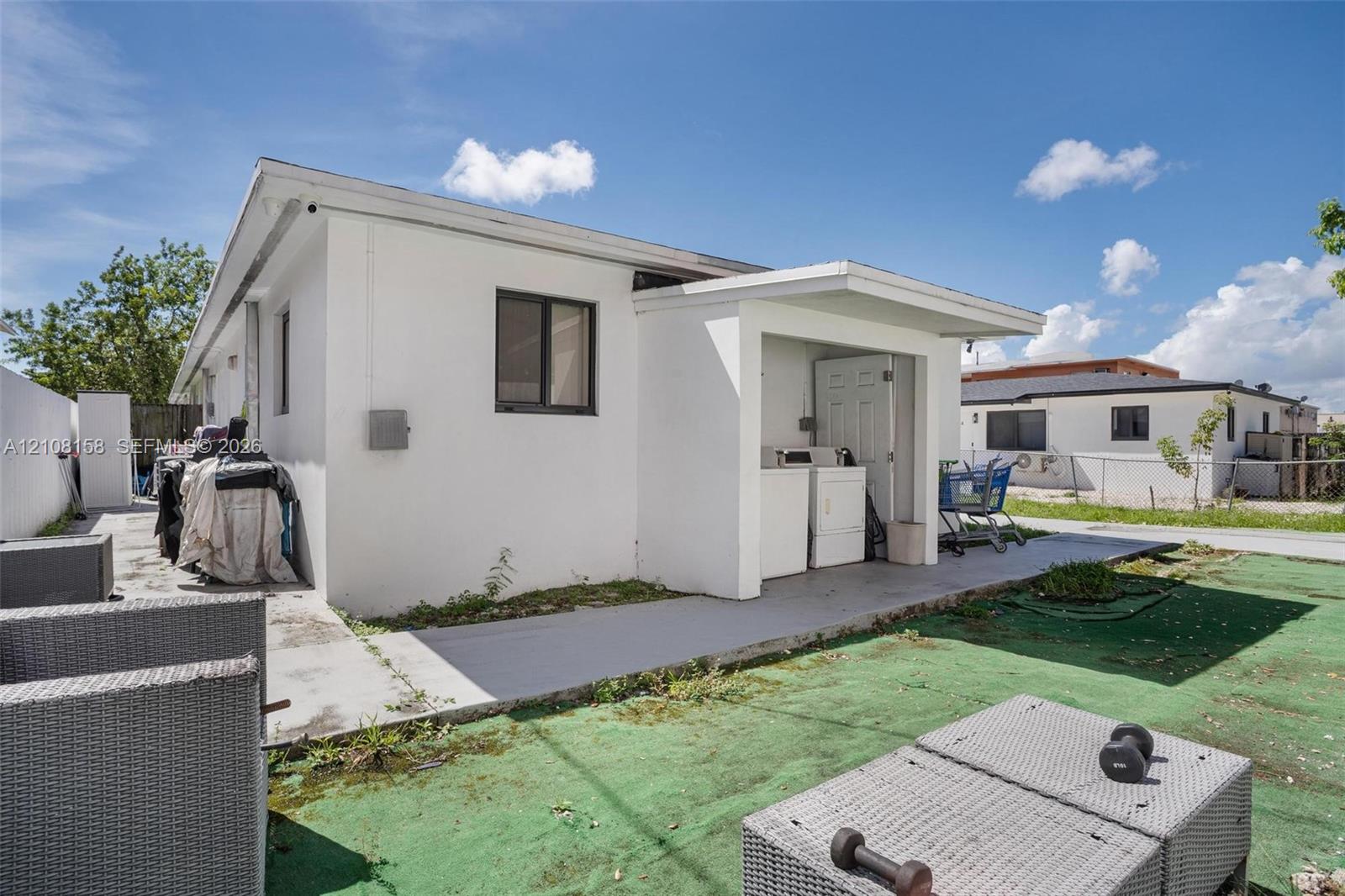 Exterior stucco finish featuring a covered concrete patio and a partially enclosed utility area