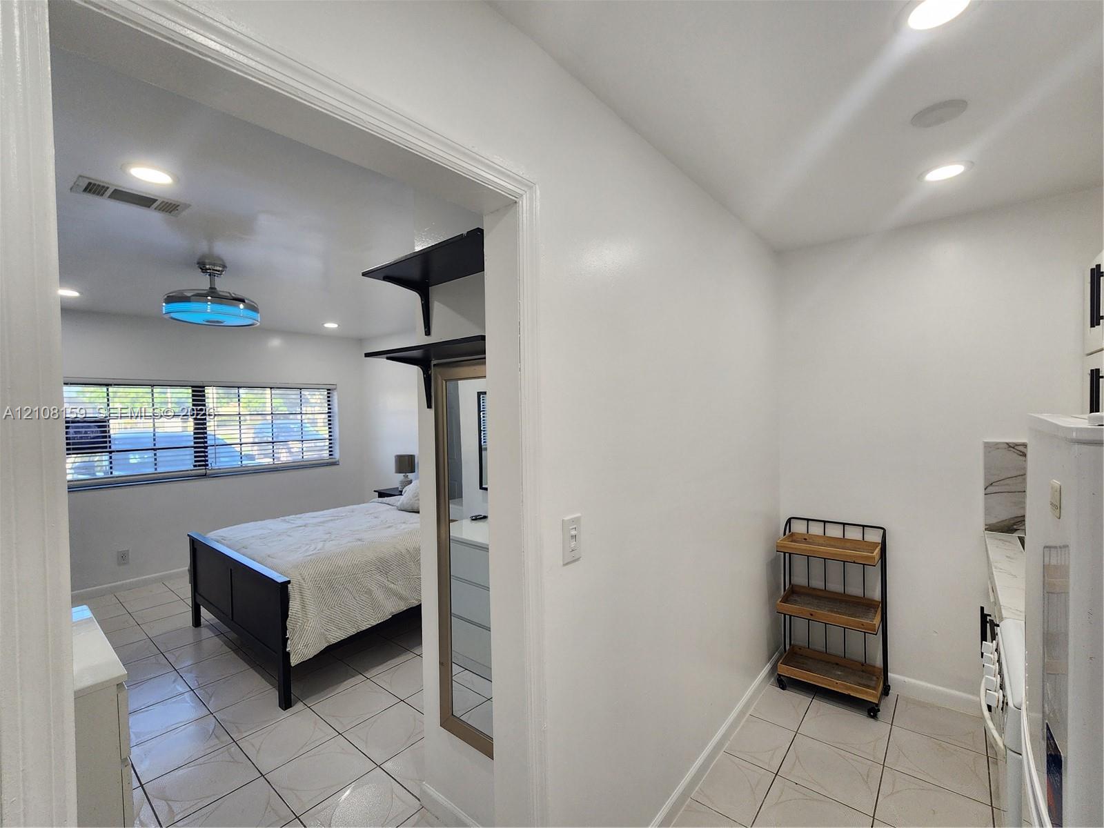 Ceramic tile flooring throughout, recessed ceiling lighting, multi-pane windows, and built-in wall shelving