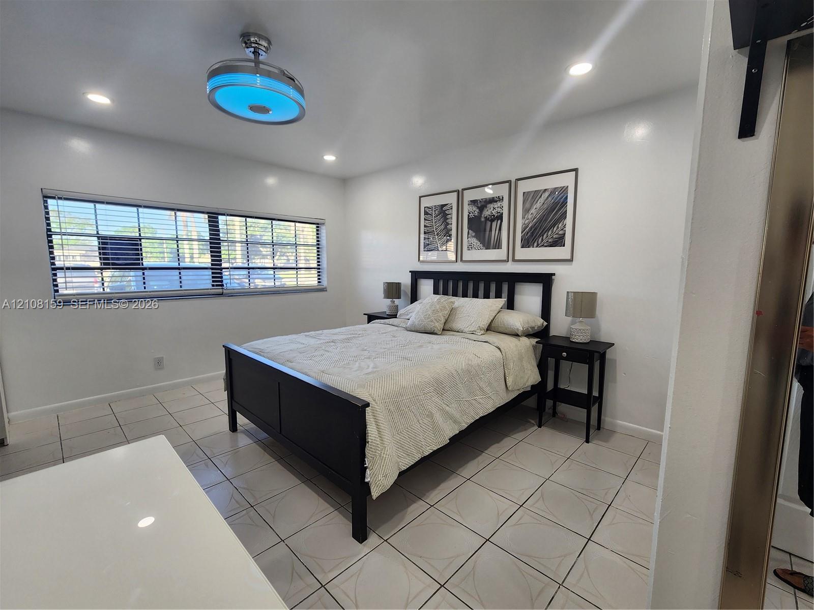 Ceramic tile flooring, recessed lighting, and a modern circular ceiling fan fixture with integrated lighting