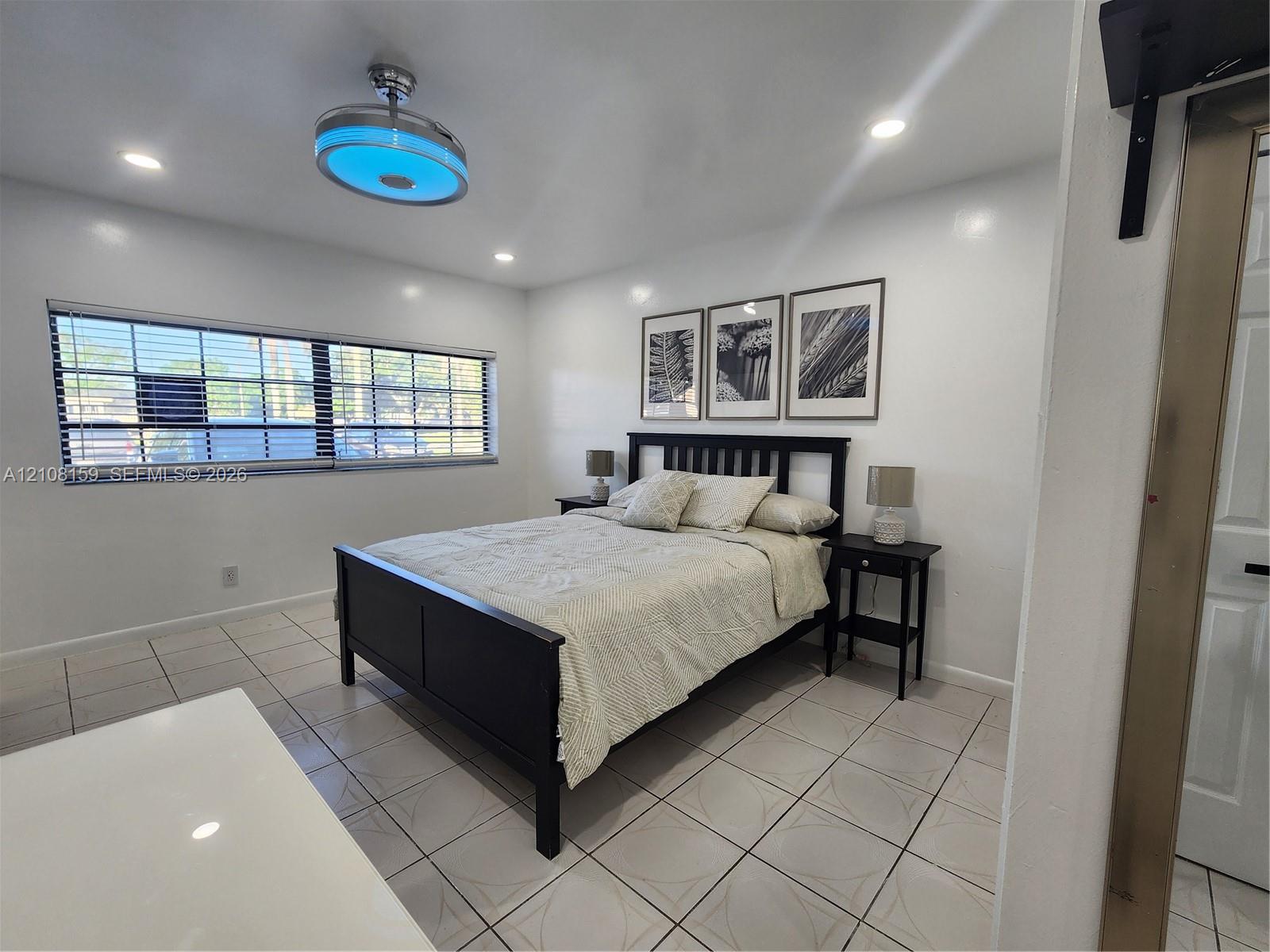 Ceramic tile flooring, recessed lighting, and a contemporary ceiling fan with integrated lighting