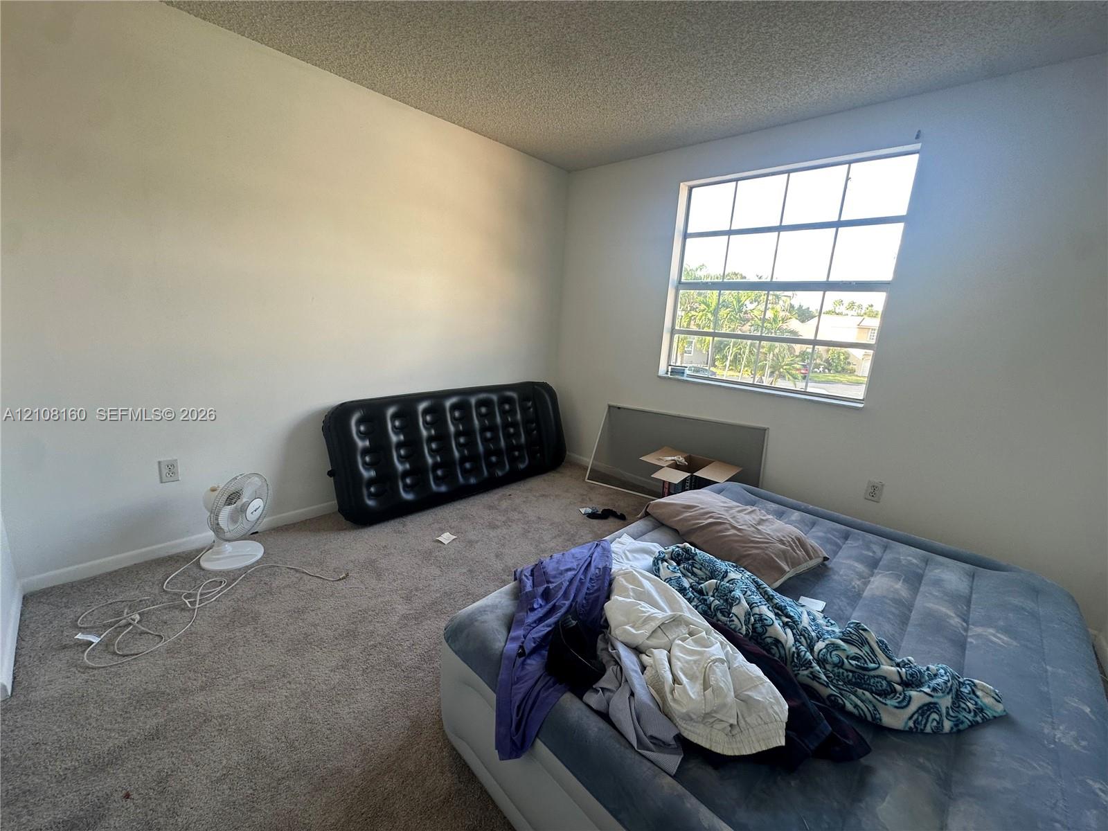 Room featuring neutral wall finishes, carpeting, and a multi-pane window