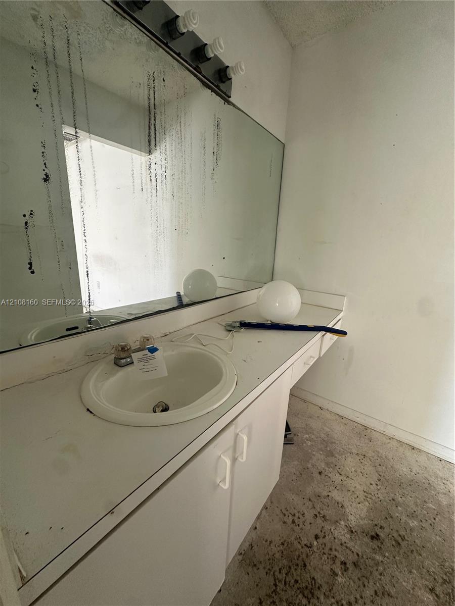 Vanity featuring an integrated white sink, countertop, and lower cabinetry with hardware