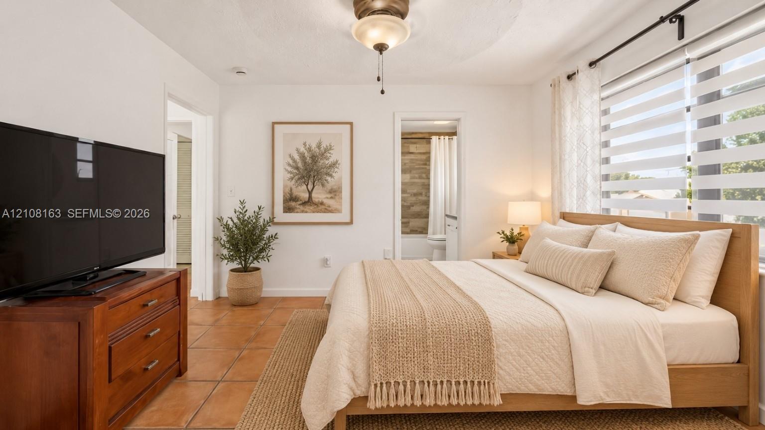 Ceramic tile flooring, neutral wall finishes, central ceiling fan with integrated lighting, and horizontal tiered window treatments
