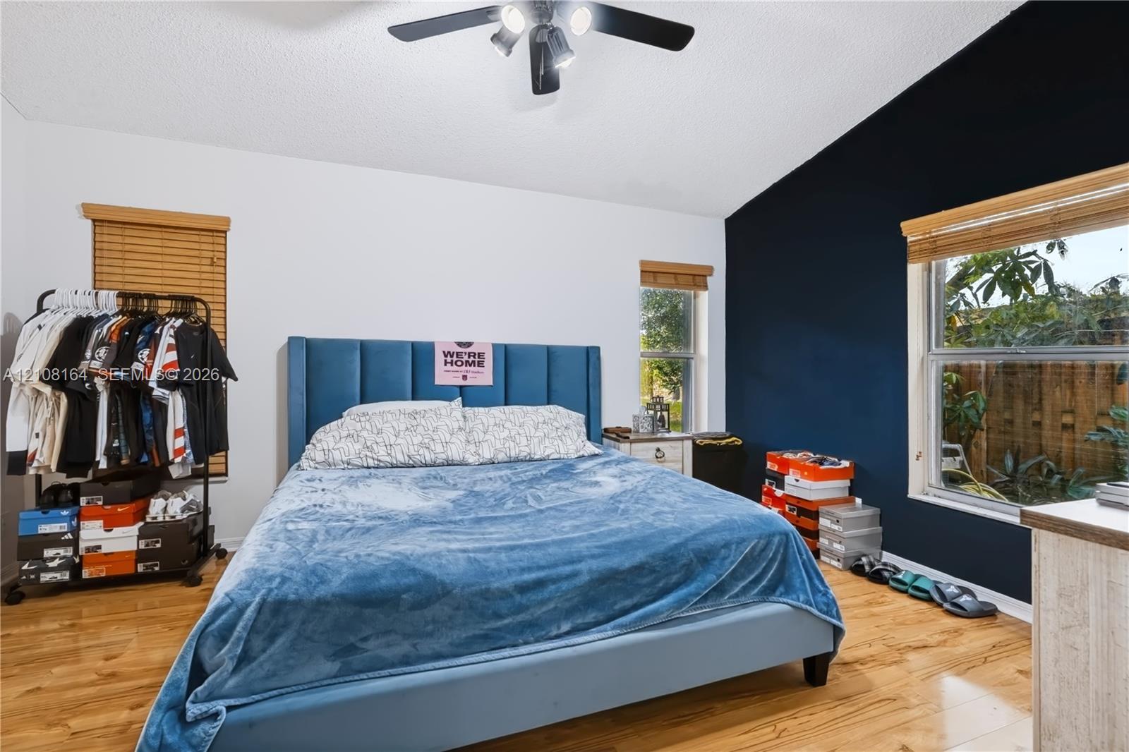 Vaulted ceilings, wood-finish flooring, and natural light via multiple windows with installed wood blinds