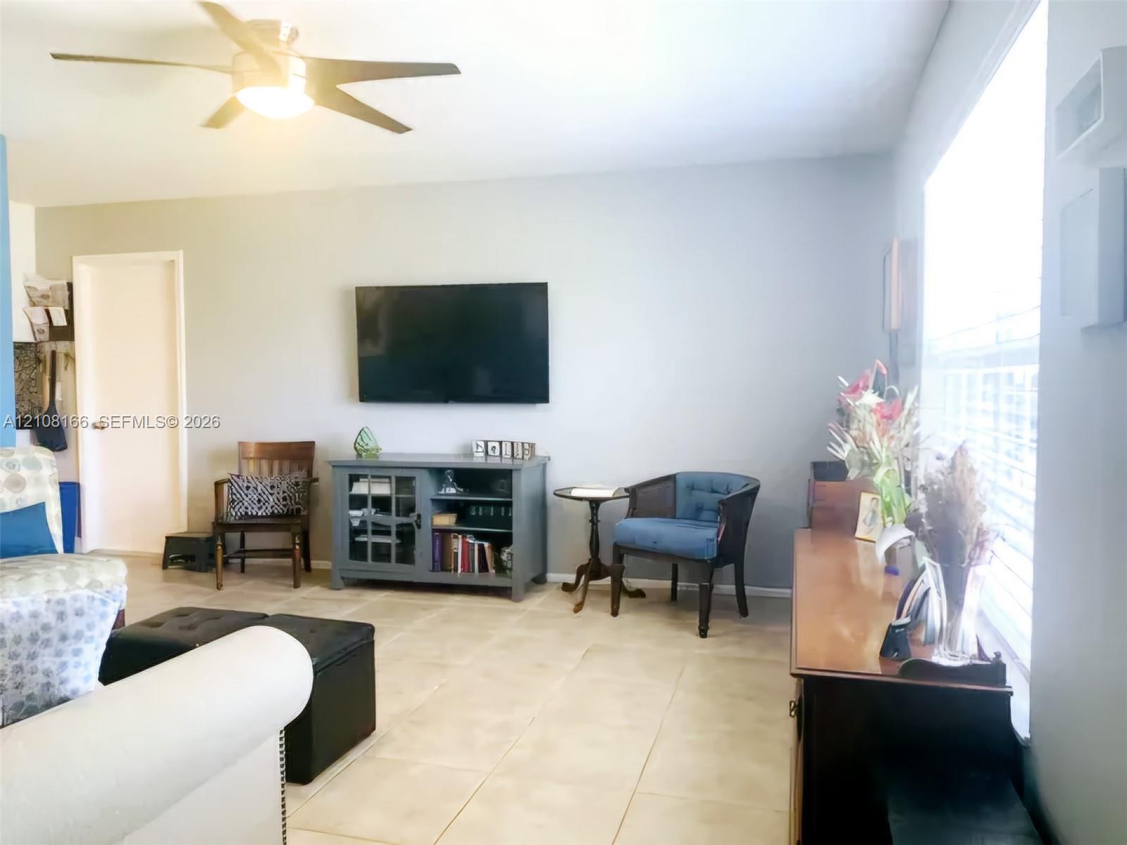 Large-format ceramic floor tile, ceiling-mounted light fixture with fan, and window featuring horizontal blinds