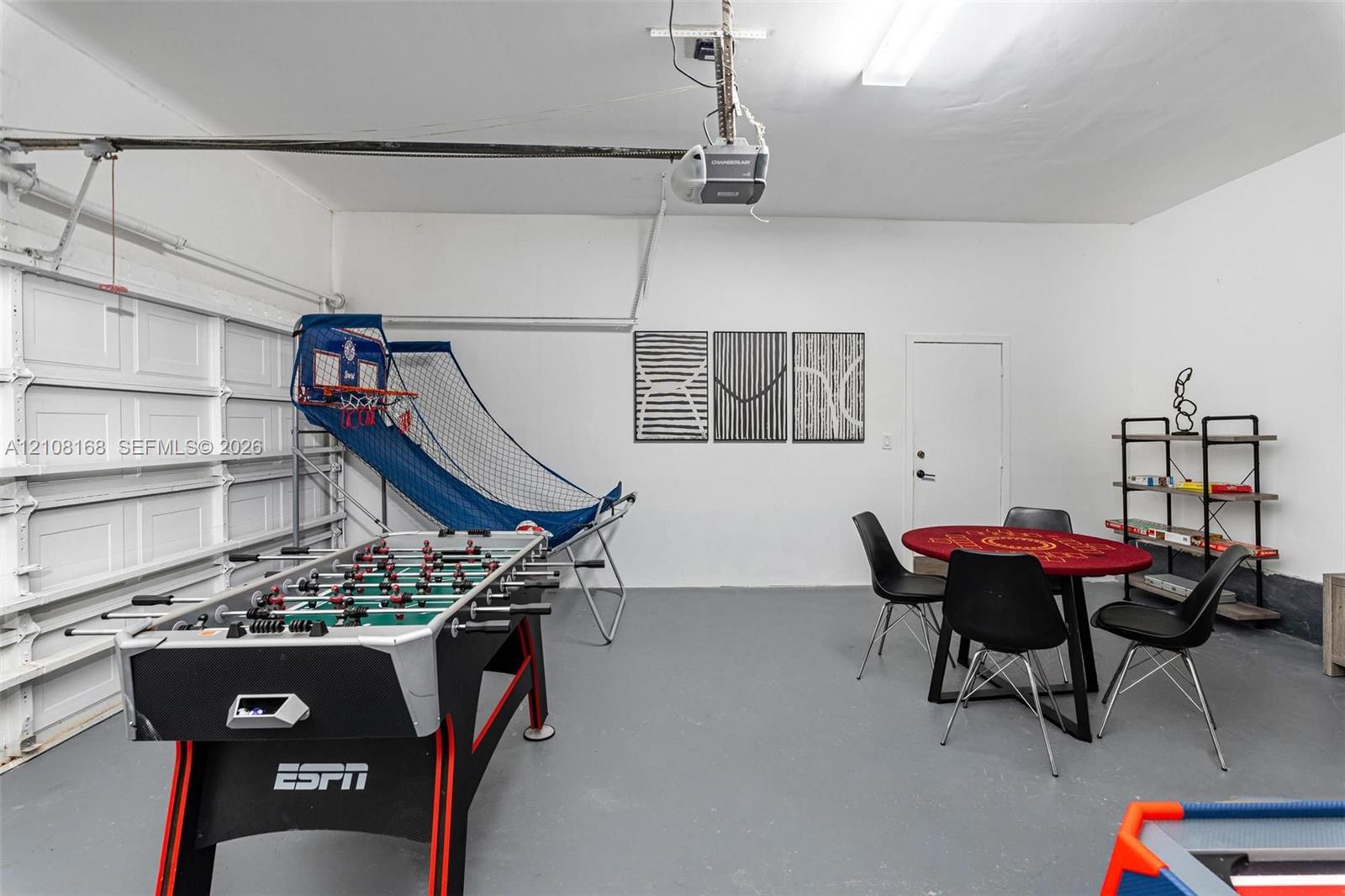 Two-car garage featuring painted walls, smooth-finish concrete flooring, a sectional roll-up door, and an integrated ceiling-mounted garage door opener