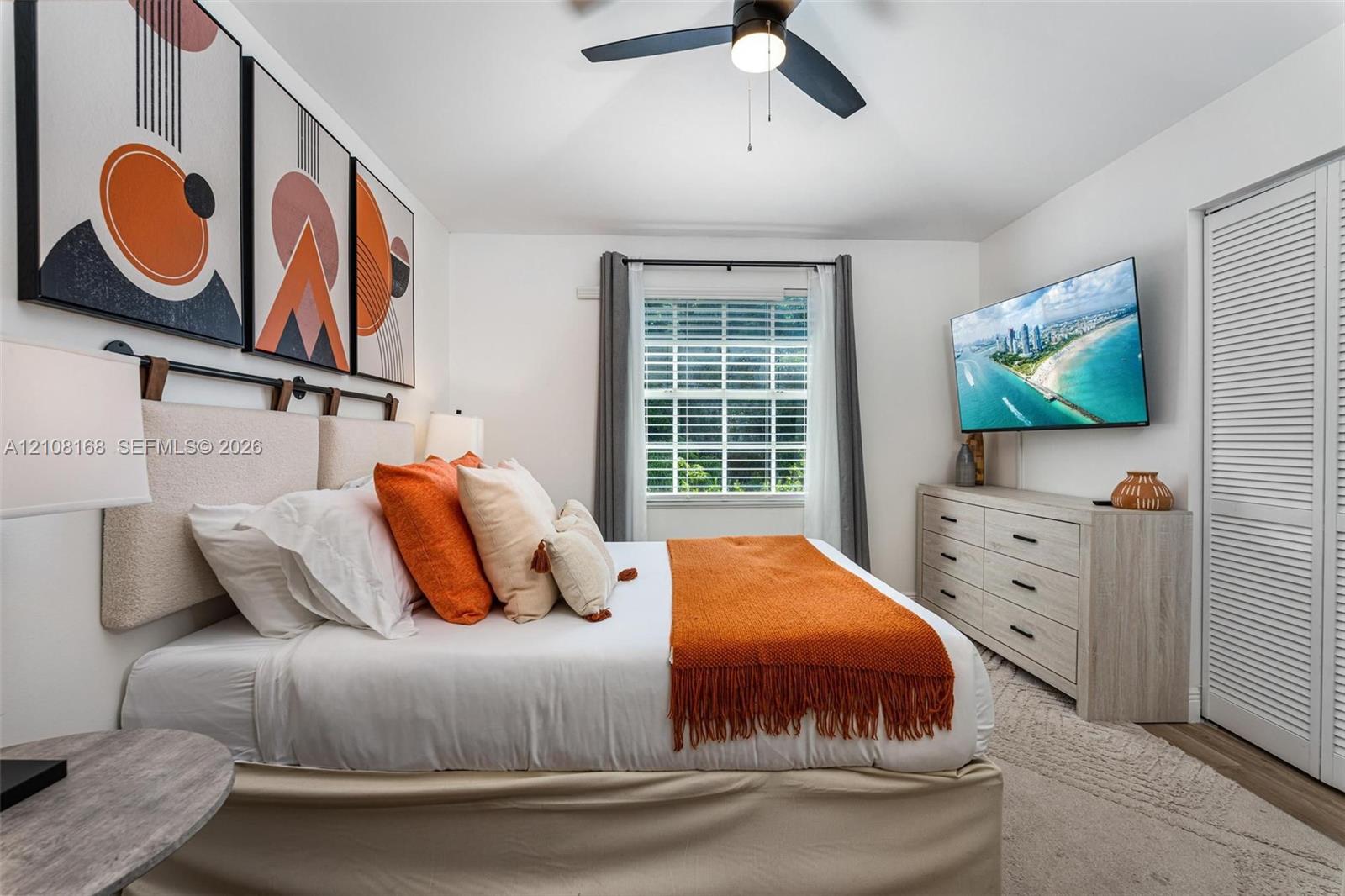 Vaulted ceiling featuring a central multi-blade ceiling fan, louvered closet doors, and horizontal window blinds