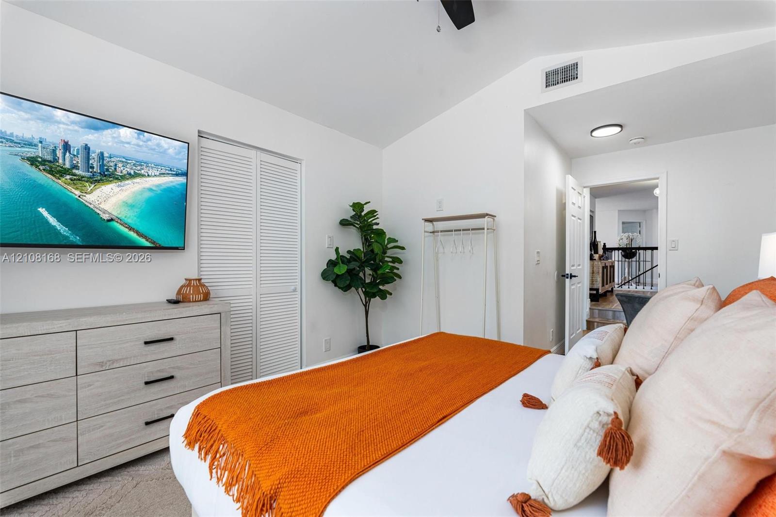 Vaulted ceilings featuring a mounted ceiling fan and neutral-toned wall-to-wall carpeting