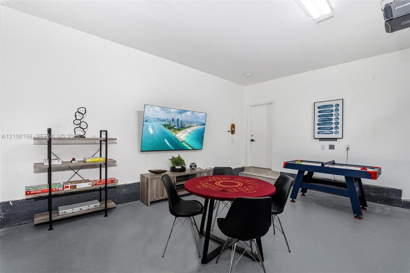 Finished garage space featuring epoxy-coated flooring, neutral wall finishes, and an integrated ceiling-mounted light fixture