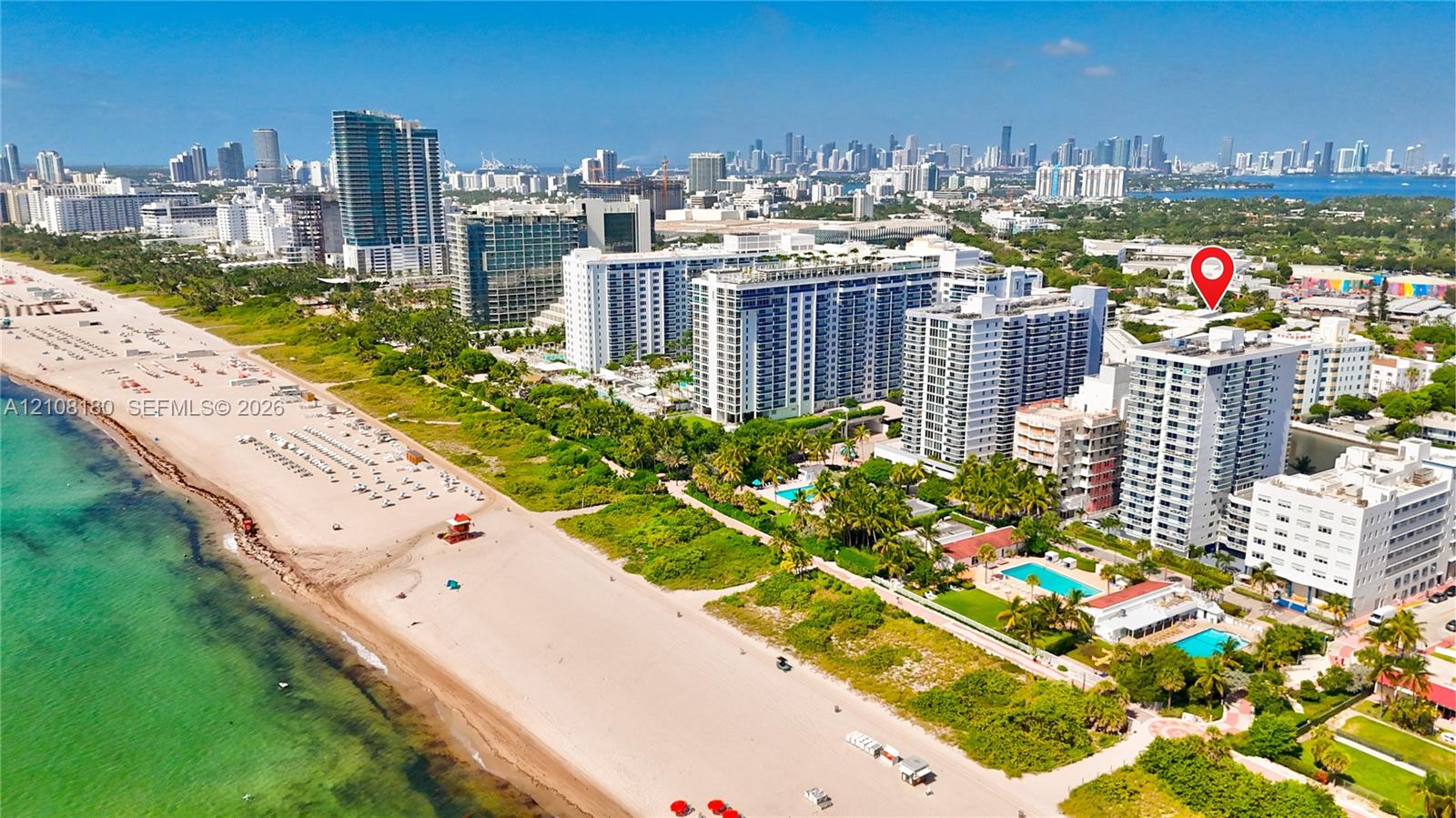 Aerial perspective of a multi-story residential building located in a coastal urban environment featuring immediate proximity to the Atlantic shoreline and surrounding high-rise infrastructure Aerial perspective of a multi-story residential building located in a coastal urban environment featuring immediate proximity to the Atlantic shoreline and surrounding high-rise infrastructure