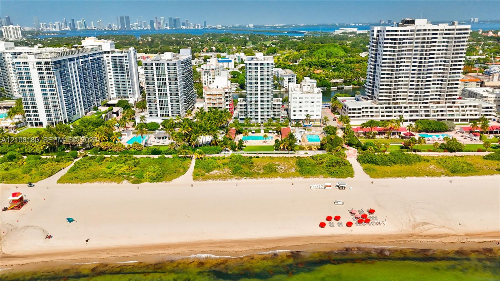 Aerial perspective of oceanfront property featuring sandy beach access, mature tropical landscaping, and outdoor swimming pools Aerial perspective of oceanfront property featuring sandy beach access, mature tropical landscaping, and outdoor swimming pools