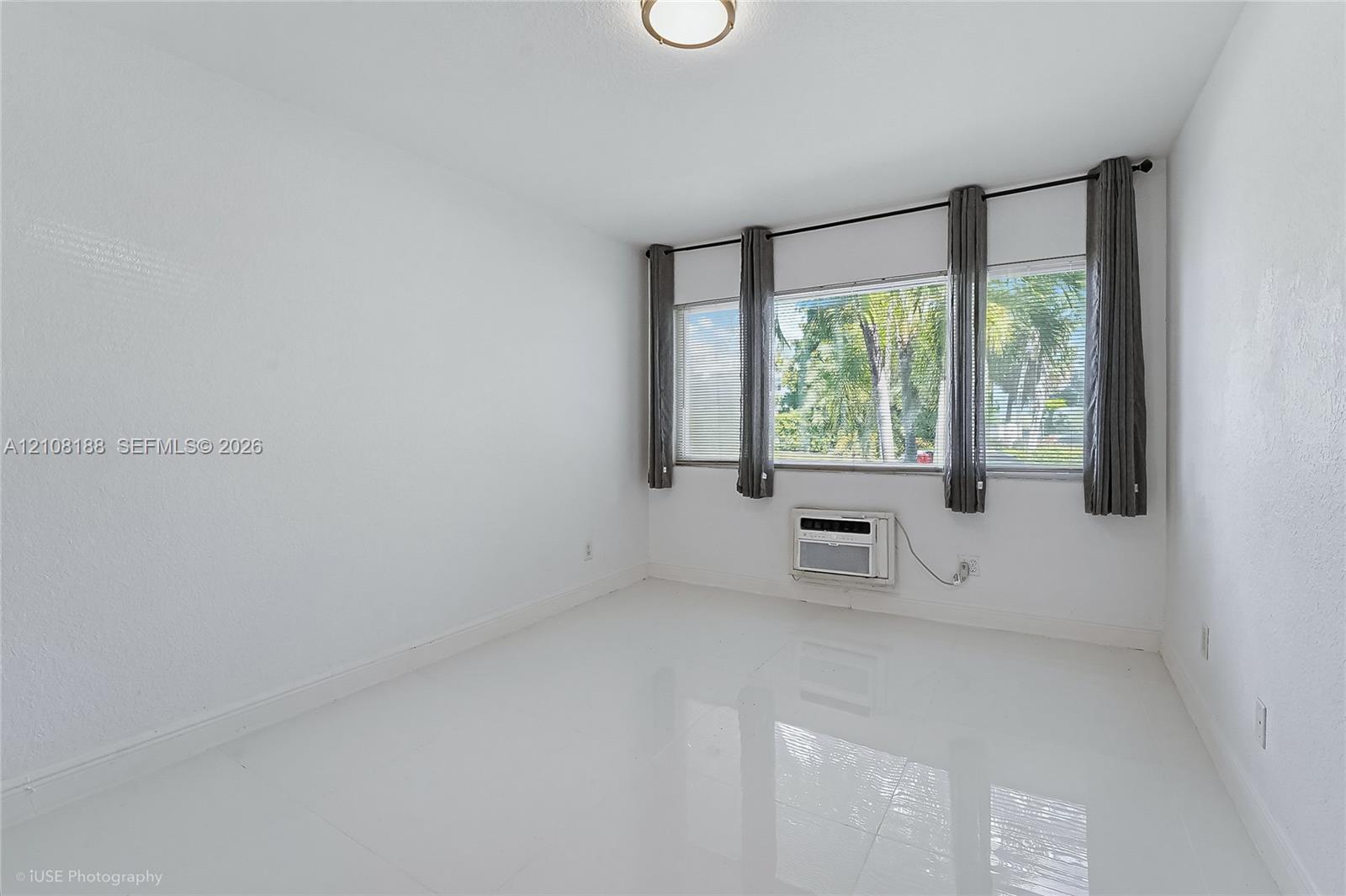 Room featuring polished tile flooring, expansive triple-pane window configuration, and flush-mount ceiling lighting
