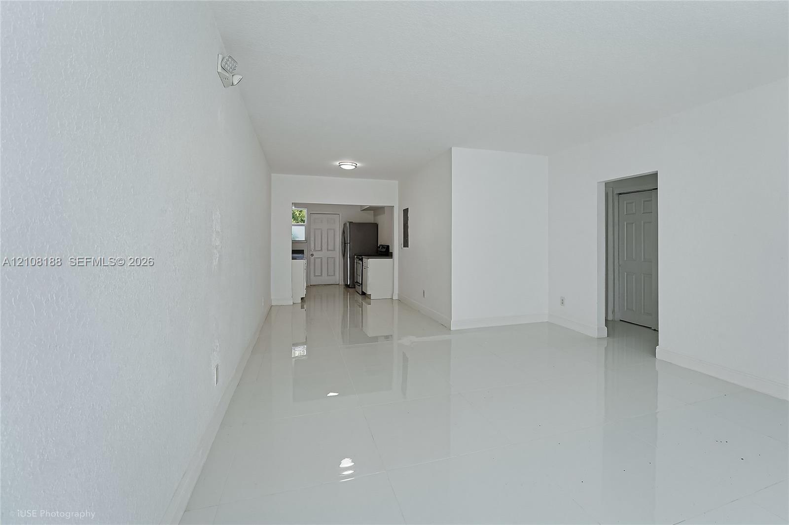Open interior featuring polished tile flooring, smooth-finish walls, recessed ceiling lighting, and six-panel interior doors
